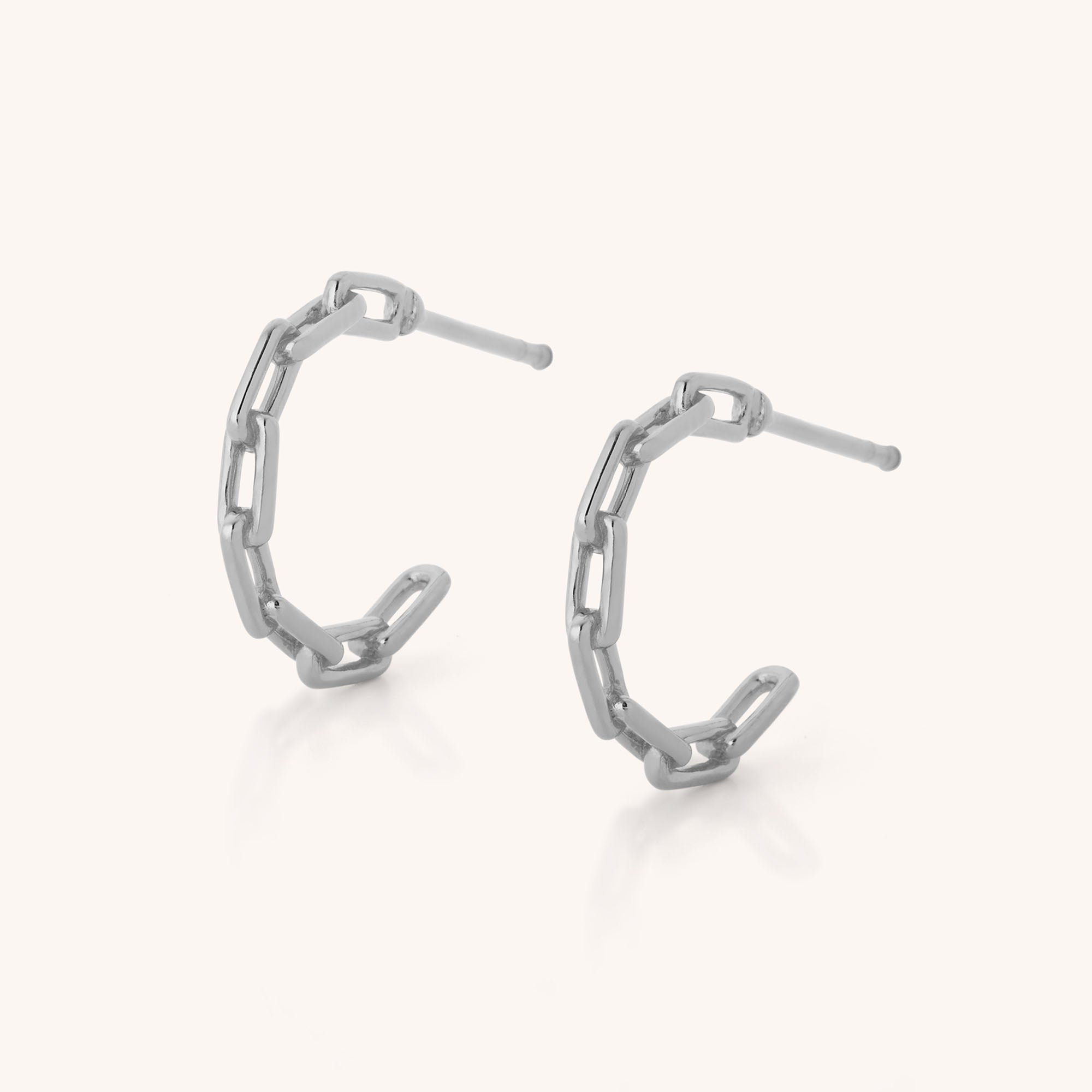 The Link Hoop Earrings feature a distinctive paperclip chain design in sterling silver, showcased on a simple light background.