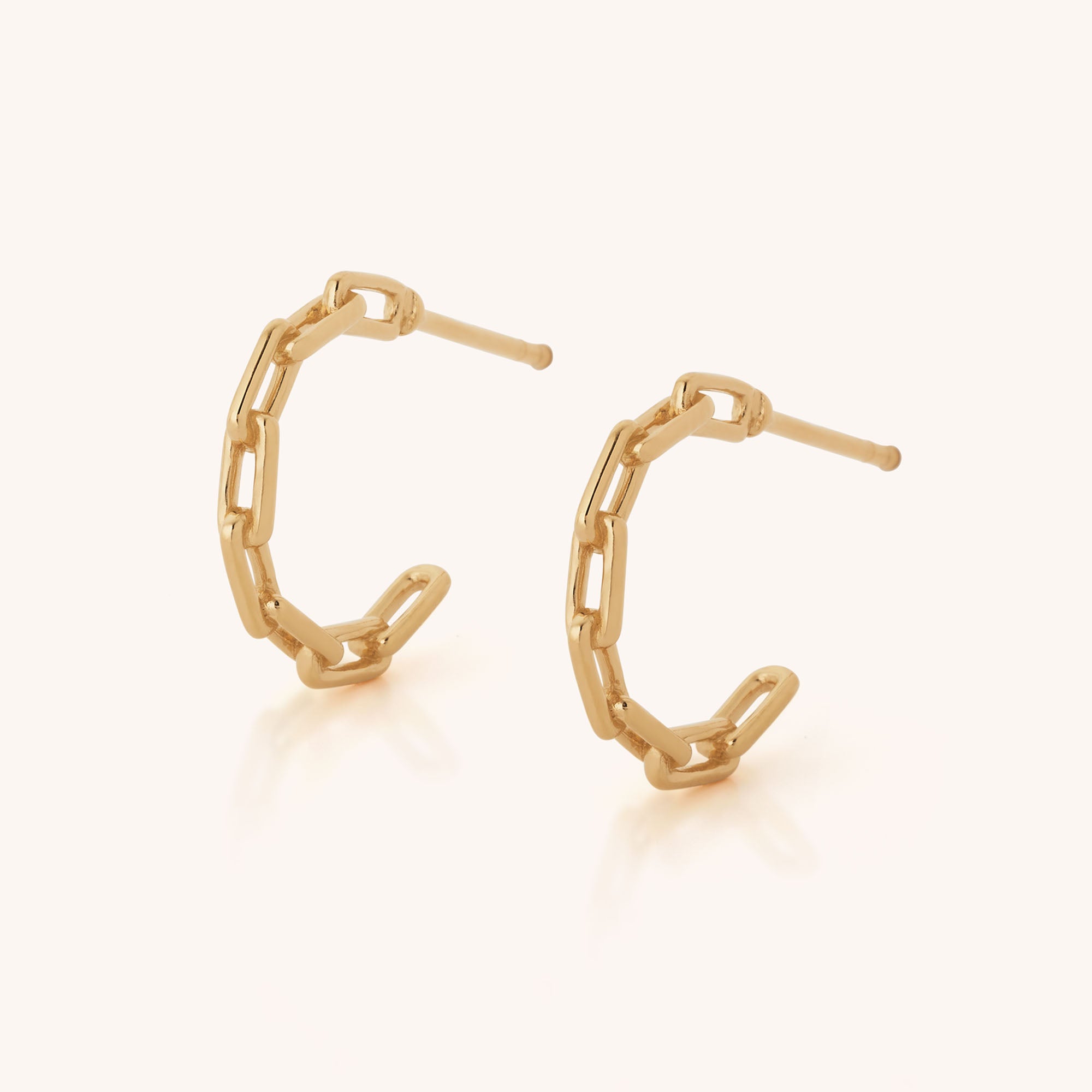 The Link Hoop Earrings feature a gold, paperclip-inspired design with small interlocking chain links, displayed against a plain light background.