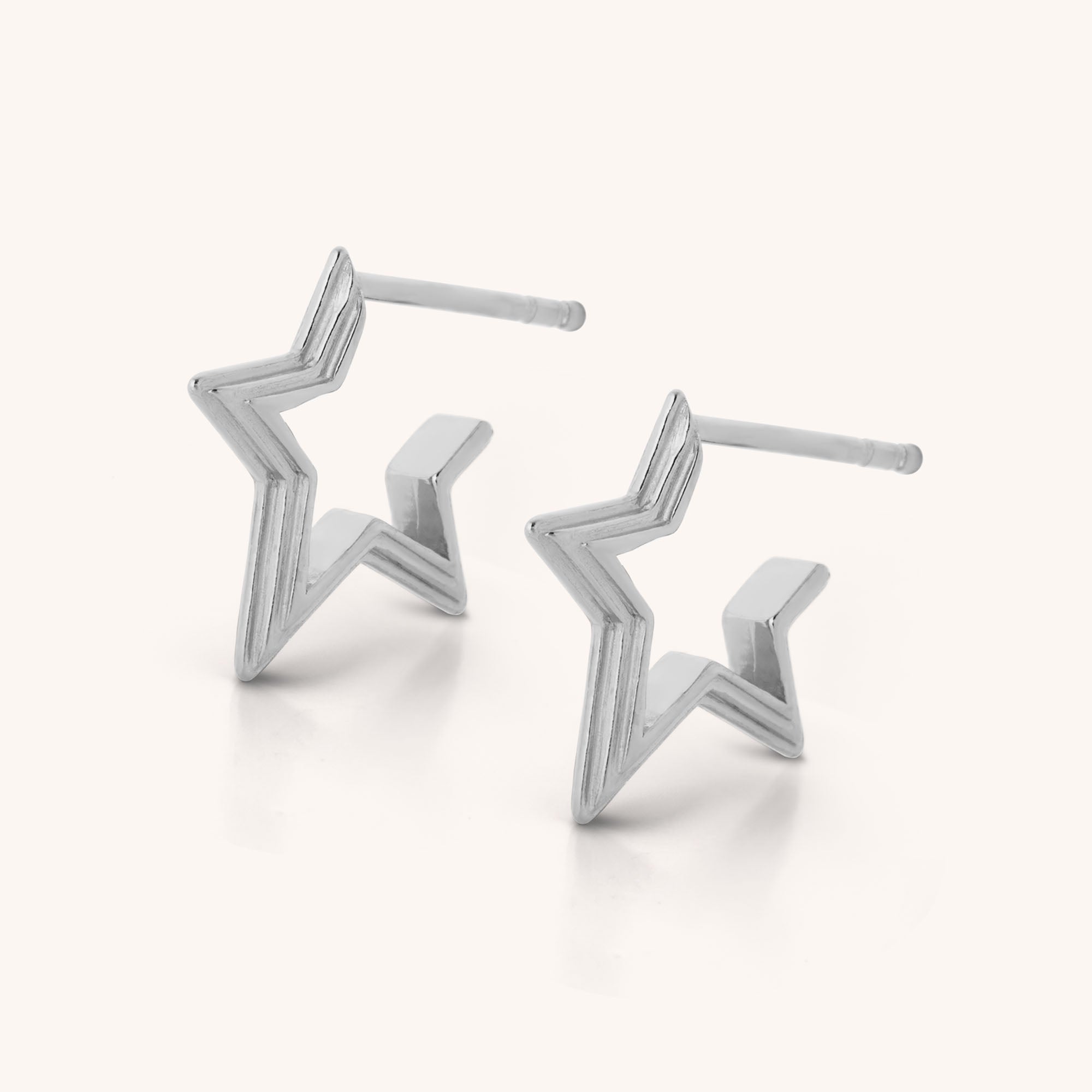 Stellar Hoop Earrings—modern, angular sterling silver hoops with celestial charm—shown against a plain light background.