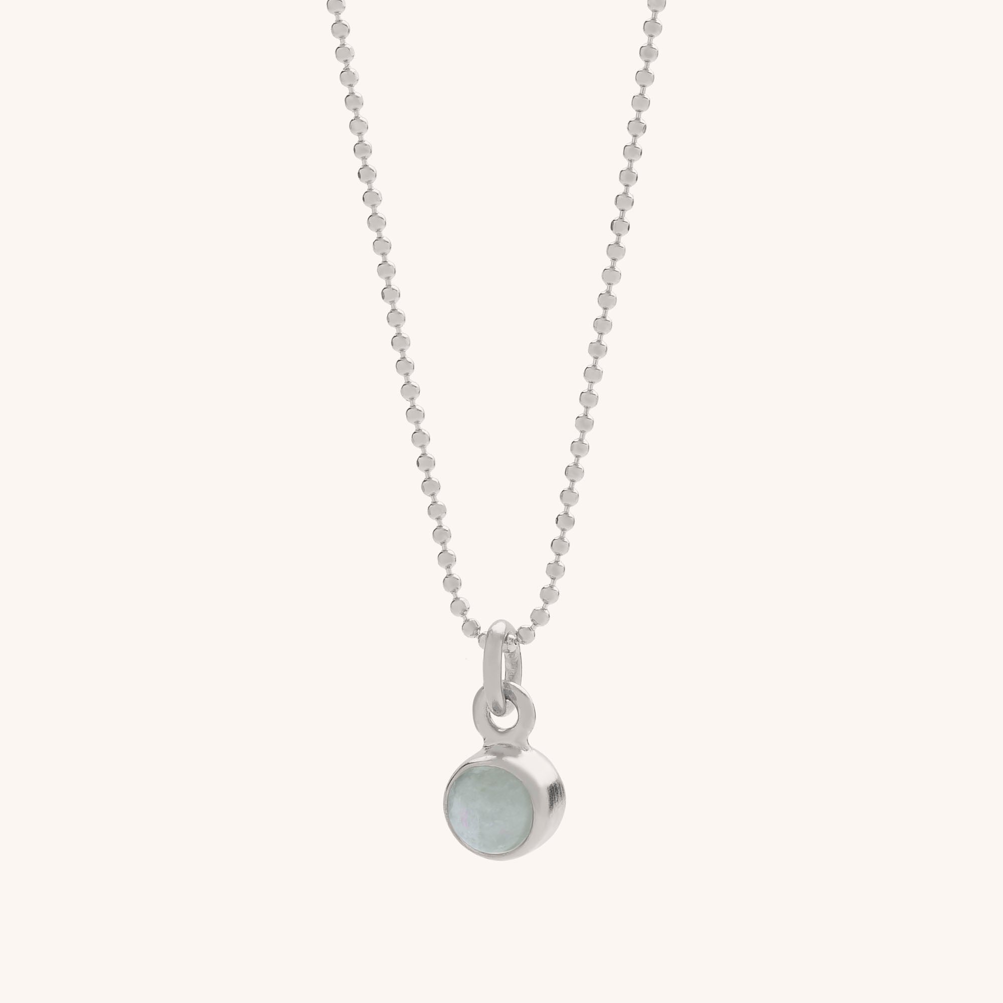 The Gem Dot Birthstone Necklace March features a delicate silver ball chain and a small round aquamarine gemstone in a silver bezel setting, shown on a plain white background.
