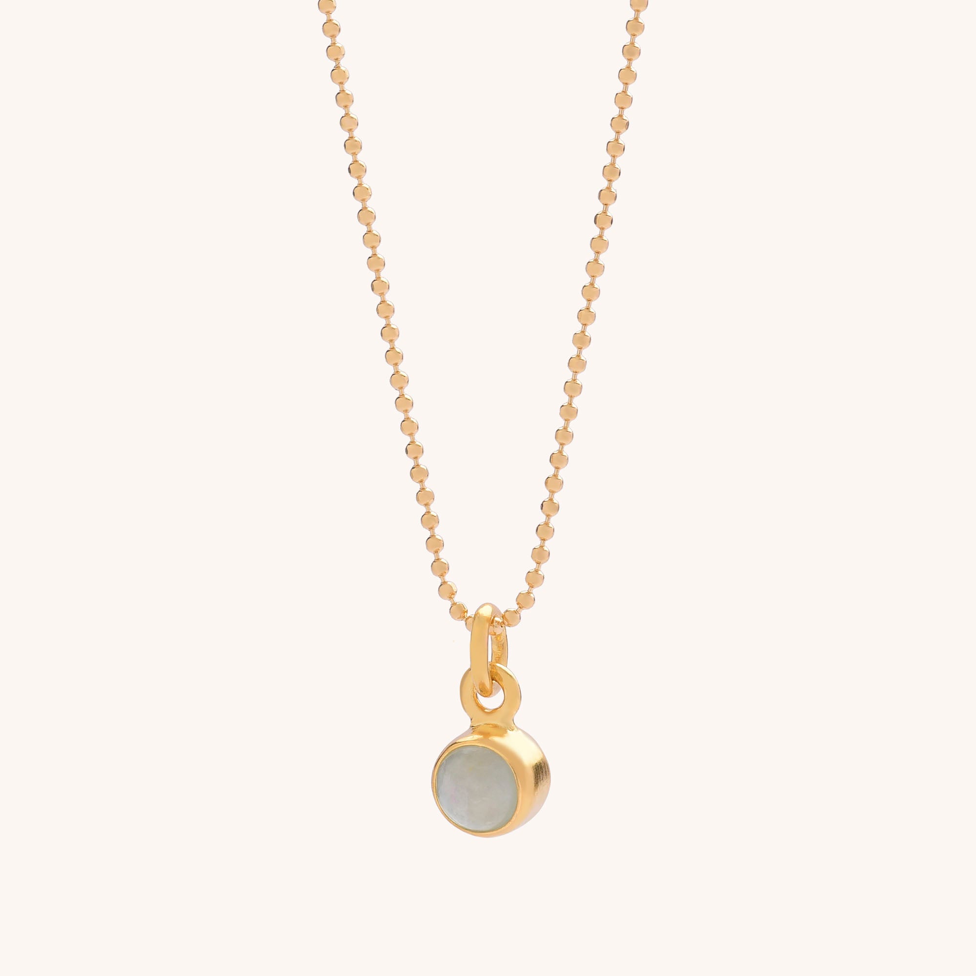 The Gem Dot Birthstone Necklace March features a delicate gold chain with a small round aquamarine pendant, set in a gold bezel—ideal as a natural gemstone or March birthstone necklace.
