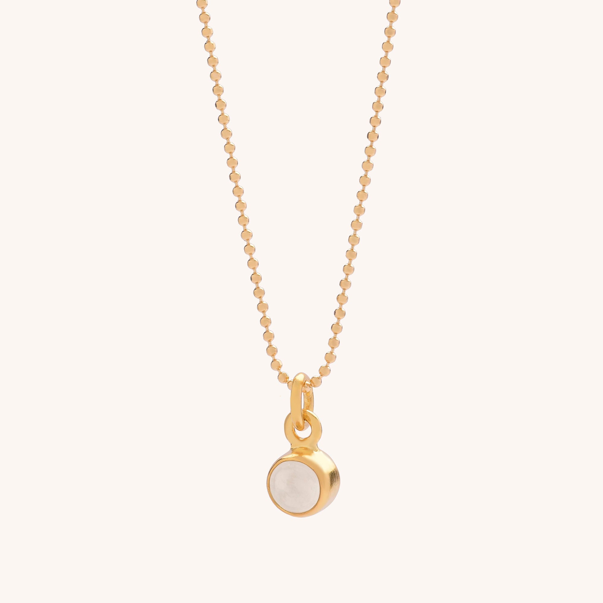 The Gem Dot Birthstone Necklace April features a delicate gold chain with a small, round, gold-framed April birthstone pendant at the center, shown on a plain light background.
