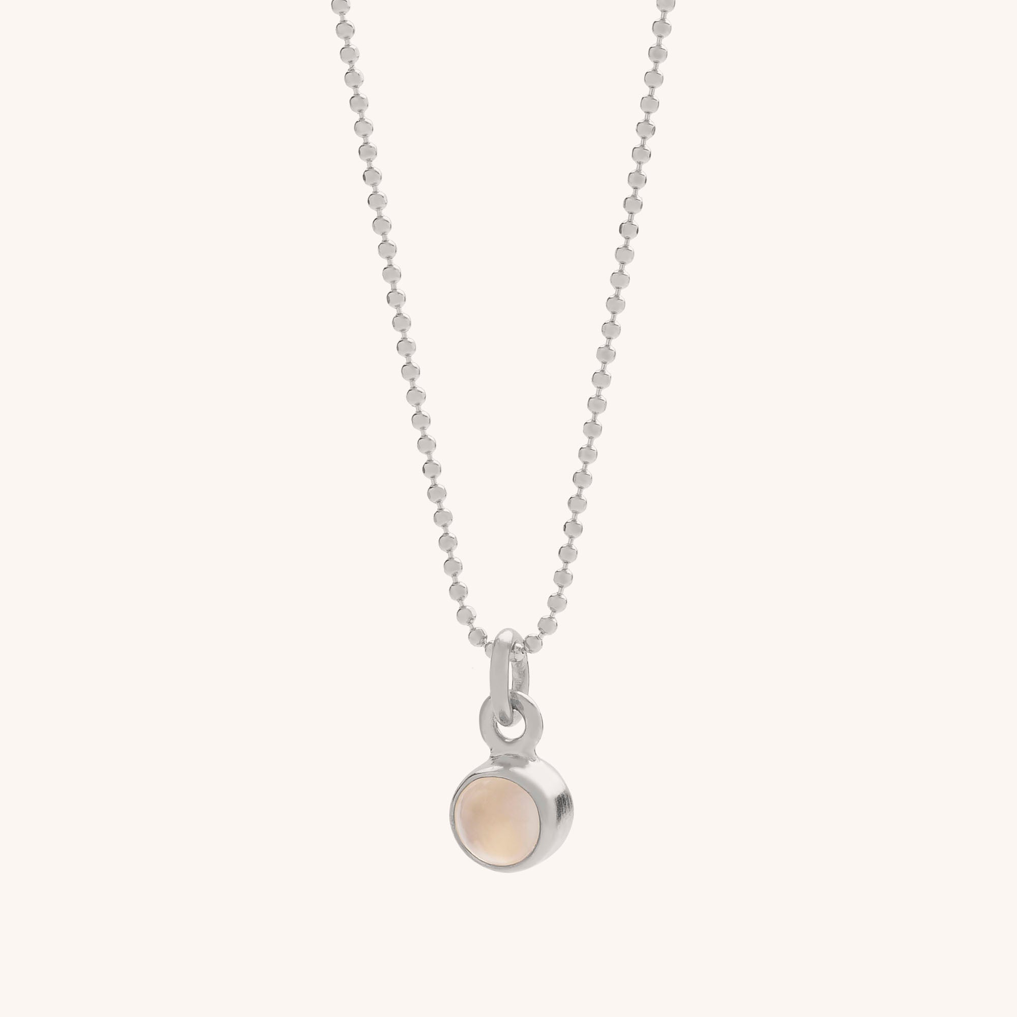 The Gem Dot Birthstone Necklace June features a delicate silver chain with a small, round moonstone pendant in a simple bezel—ideal as a June birthstone necklace or for layering with other jewellery.
