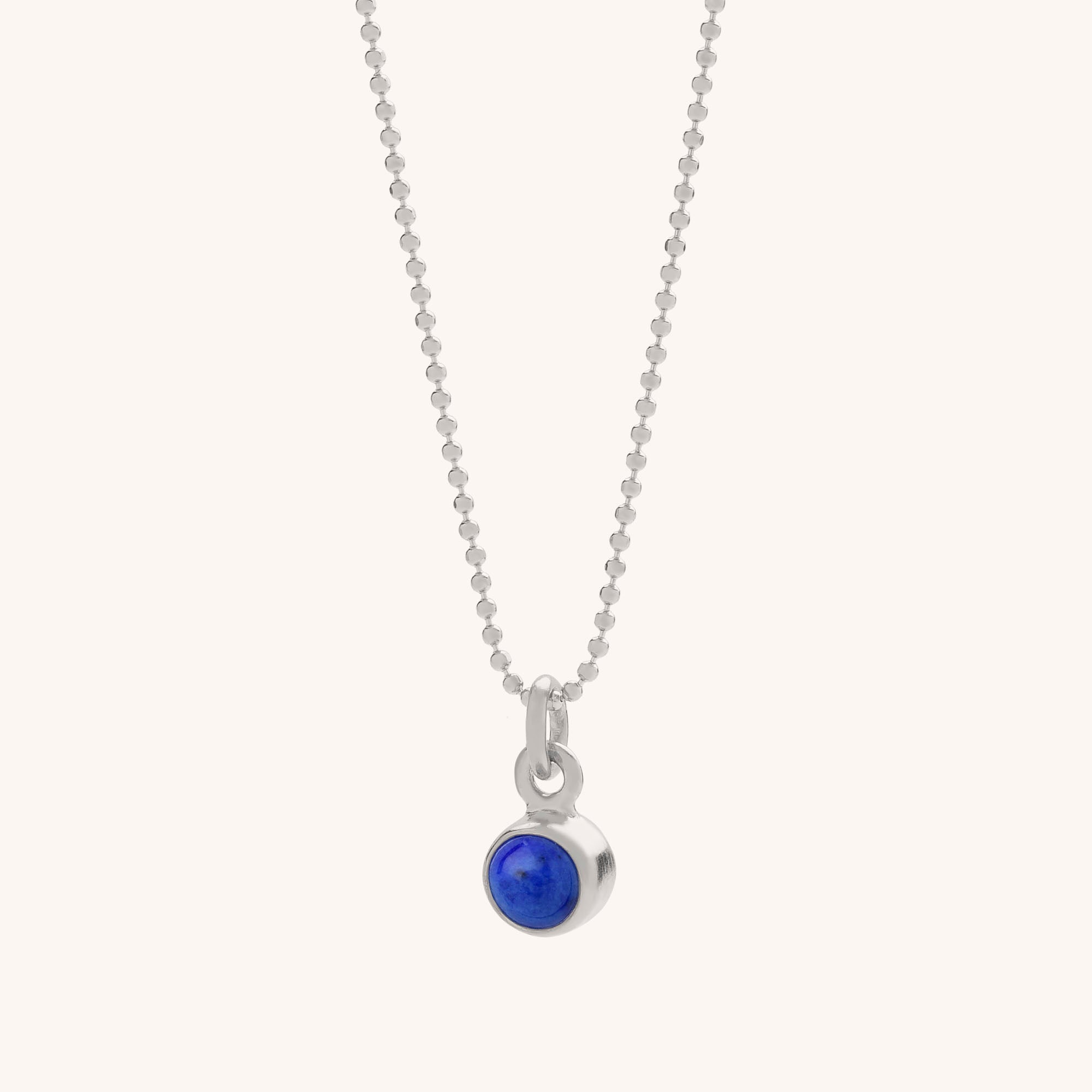 The Gem Dot Birthstone Necklace September features a fine silver beaded chain and a small round pendant set with a deep blue Lapis gemstone.