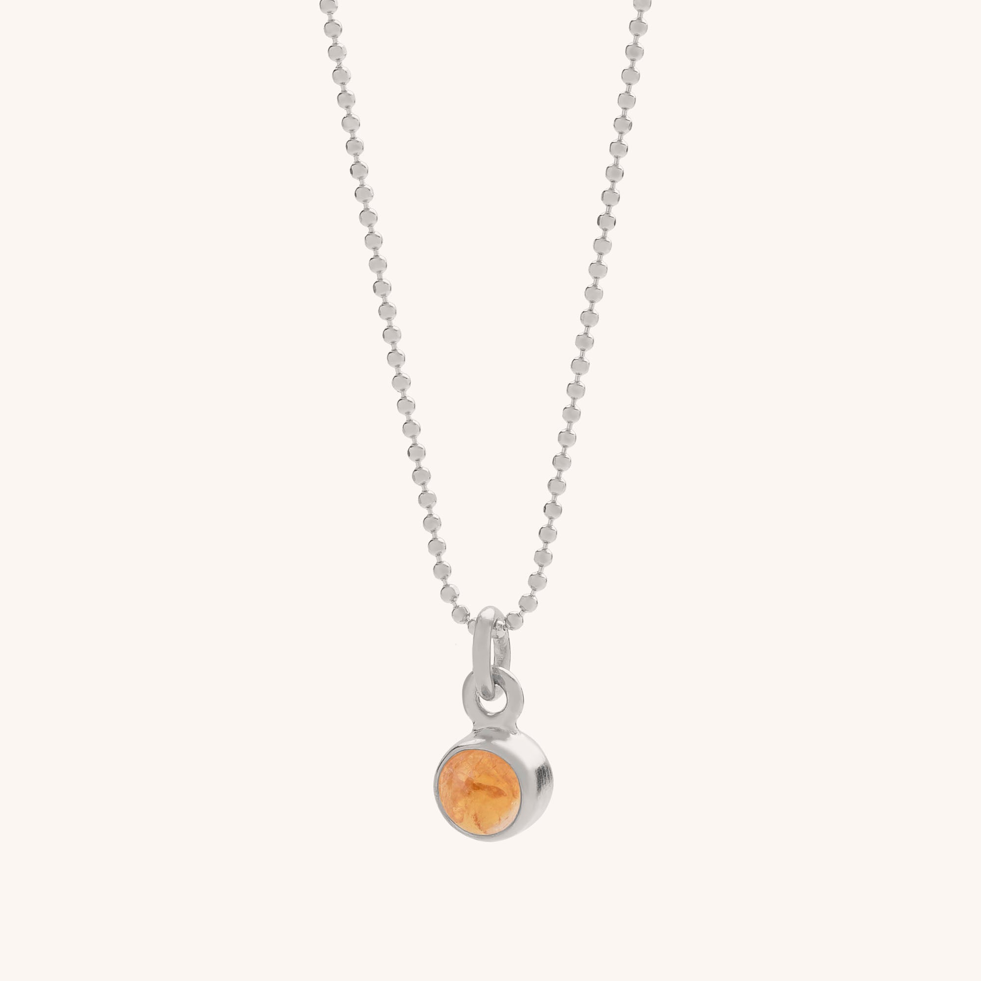 The Gem Dot Birthstone Necklace November features a silver beaded chain and a small round citrine gemstone pendant, the November birthstone, set in a sleek silver bezel.
