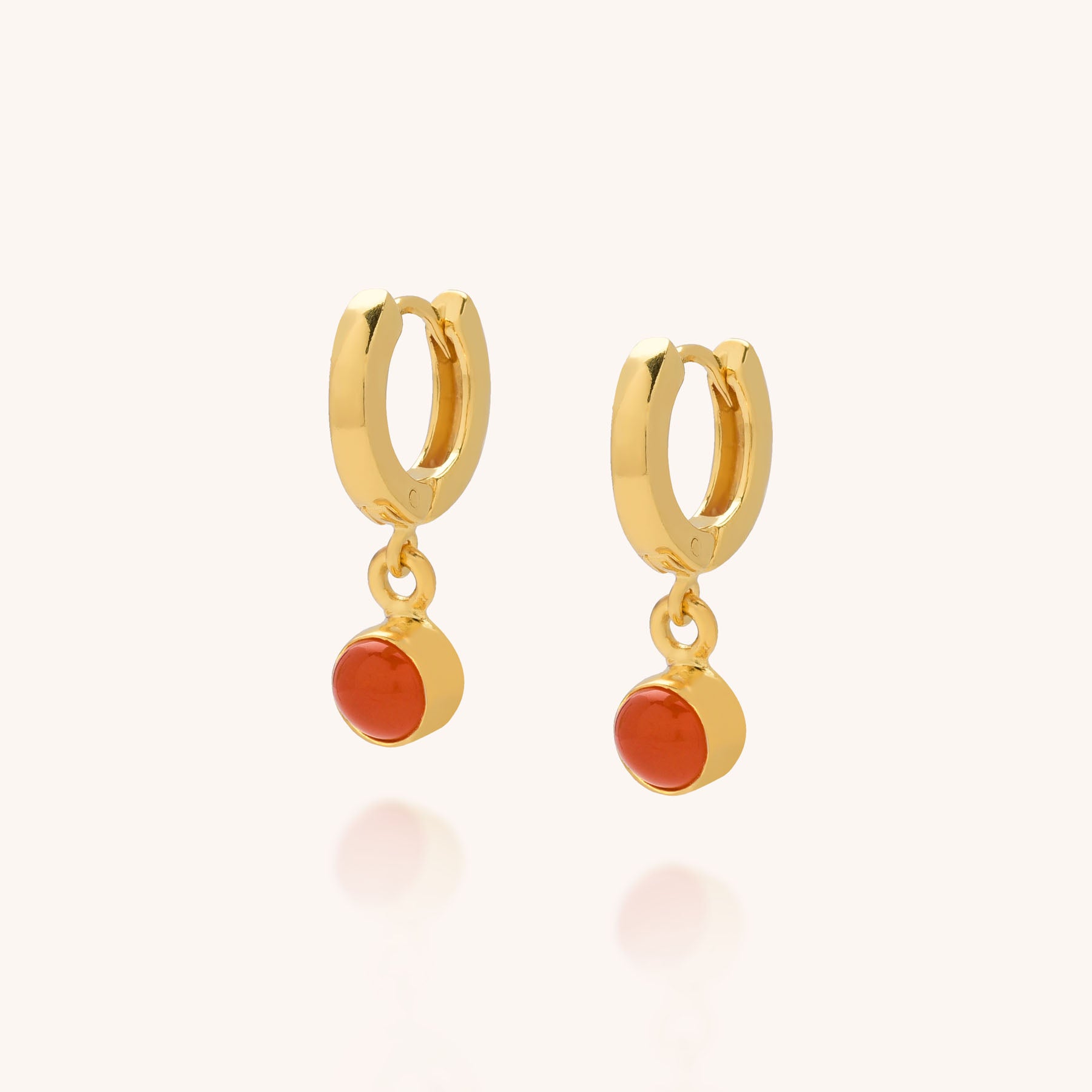 Gem Hoop Earrings - July Birthstone, each featuring a small dangling round carnelian gemstone, are displayed against a light beige background.