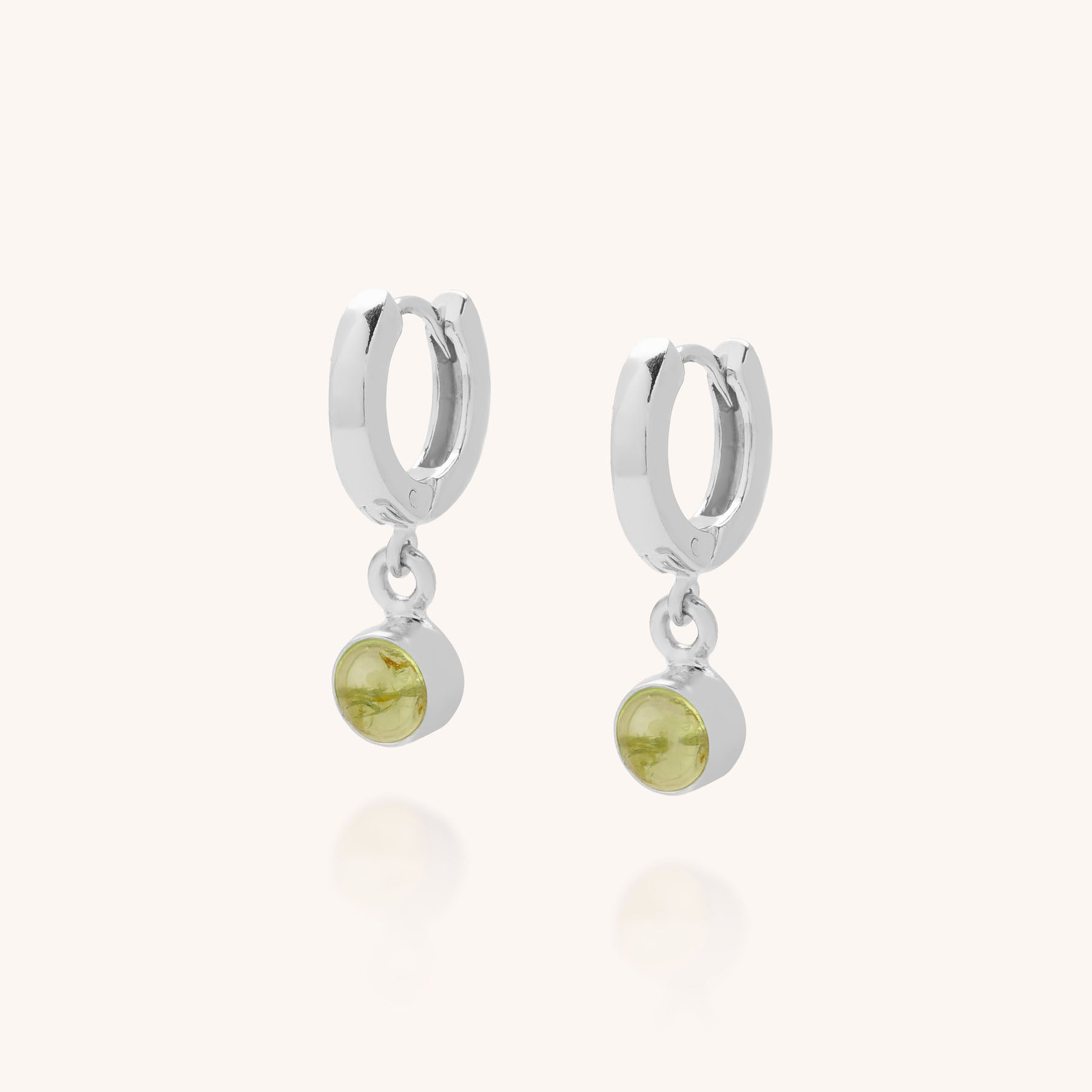 Gem Hoop Birthstone Earrings: Sterling silver hoops, each with a small round light green natural gemstone charm dangling below, shown on a plain light background.