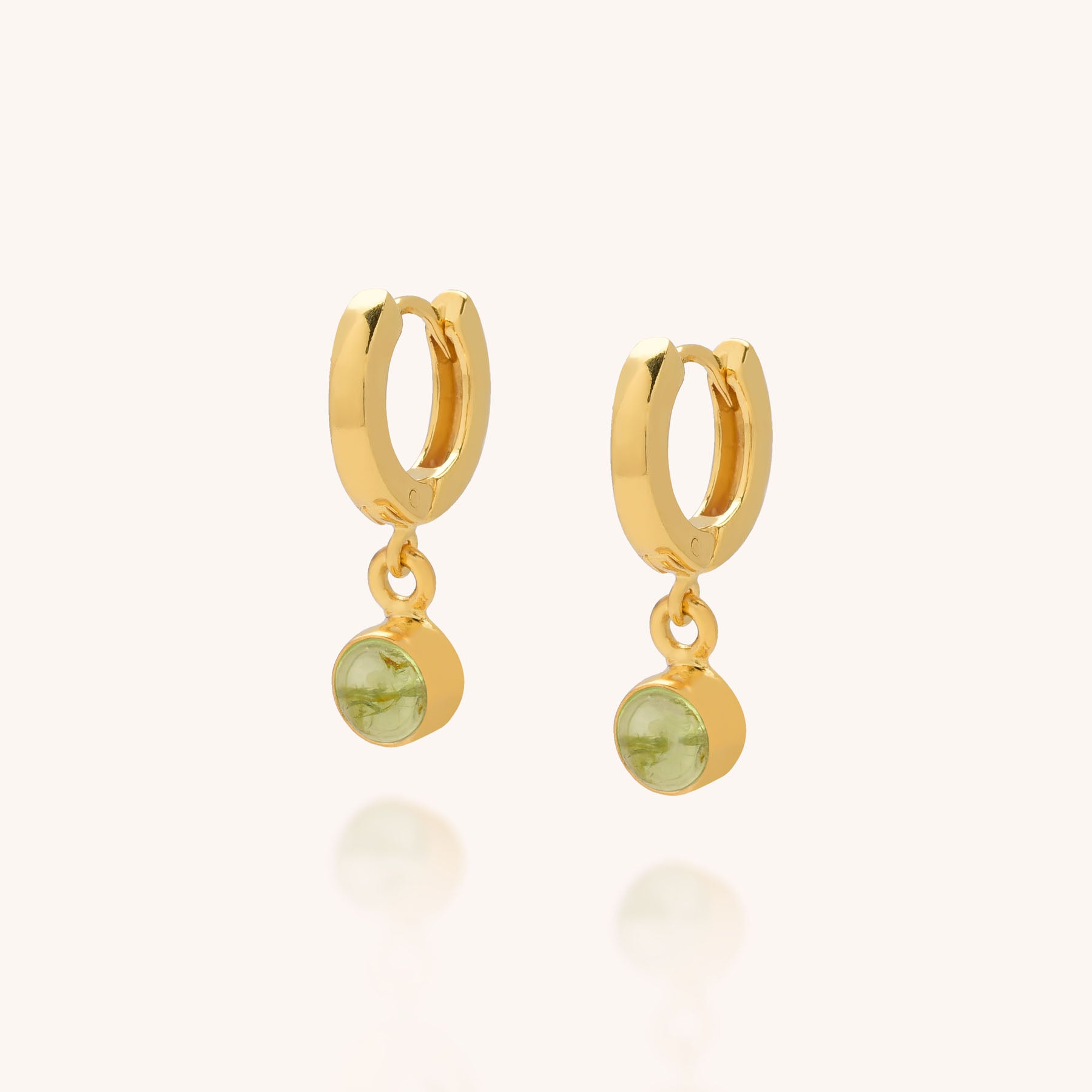 Gem Hoop Birthstone Earrings: Pair of small gold hoops, each with a dangling round green natural gemstone charm, shown on a light background.