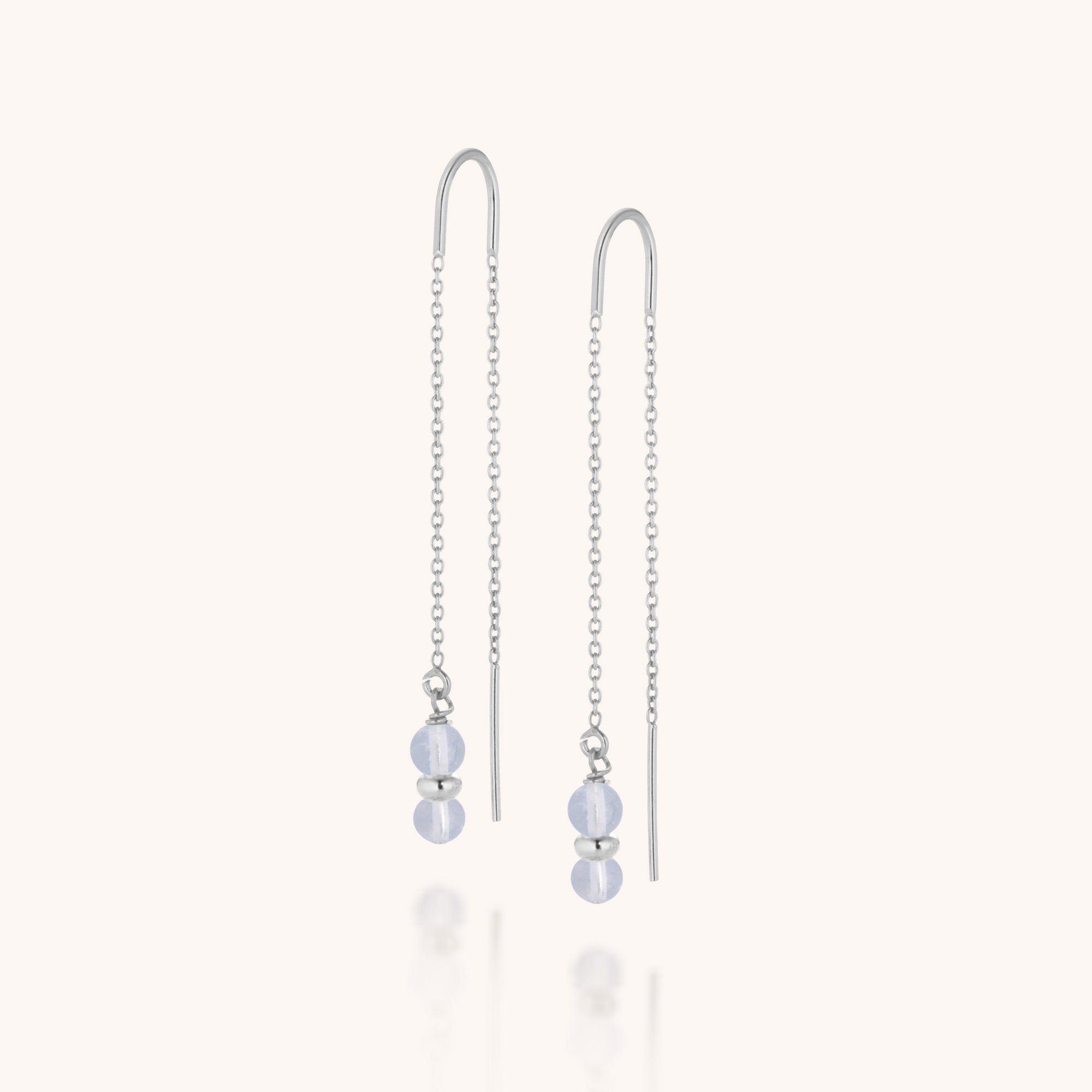 The Fall Earrings Birthstone March feature sterling silver with delicate chains, each adorned with two round Aquamarine drops separated by a small silver bead. They are elegantly displayed on a plain light background.