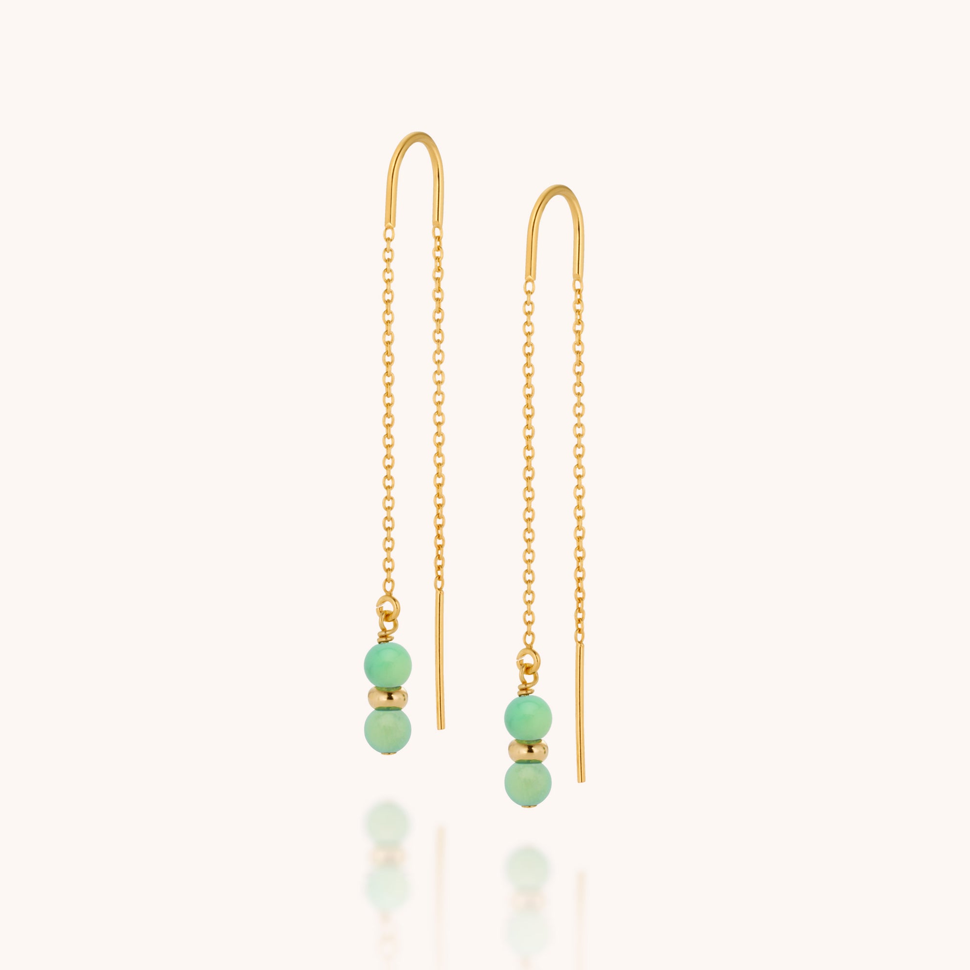 The Fall Earrings Birthstone May feature gold chains with delicate drops, each adorned with two small chrysoprase beads—the May birthstone—and a gold bead at the end, shown against a light background.