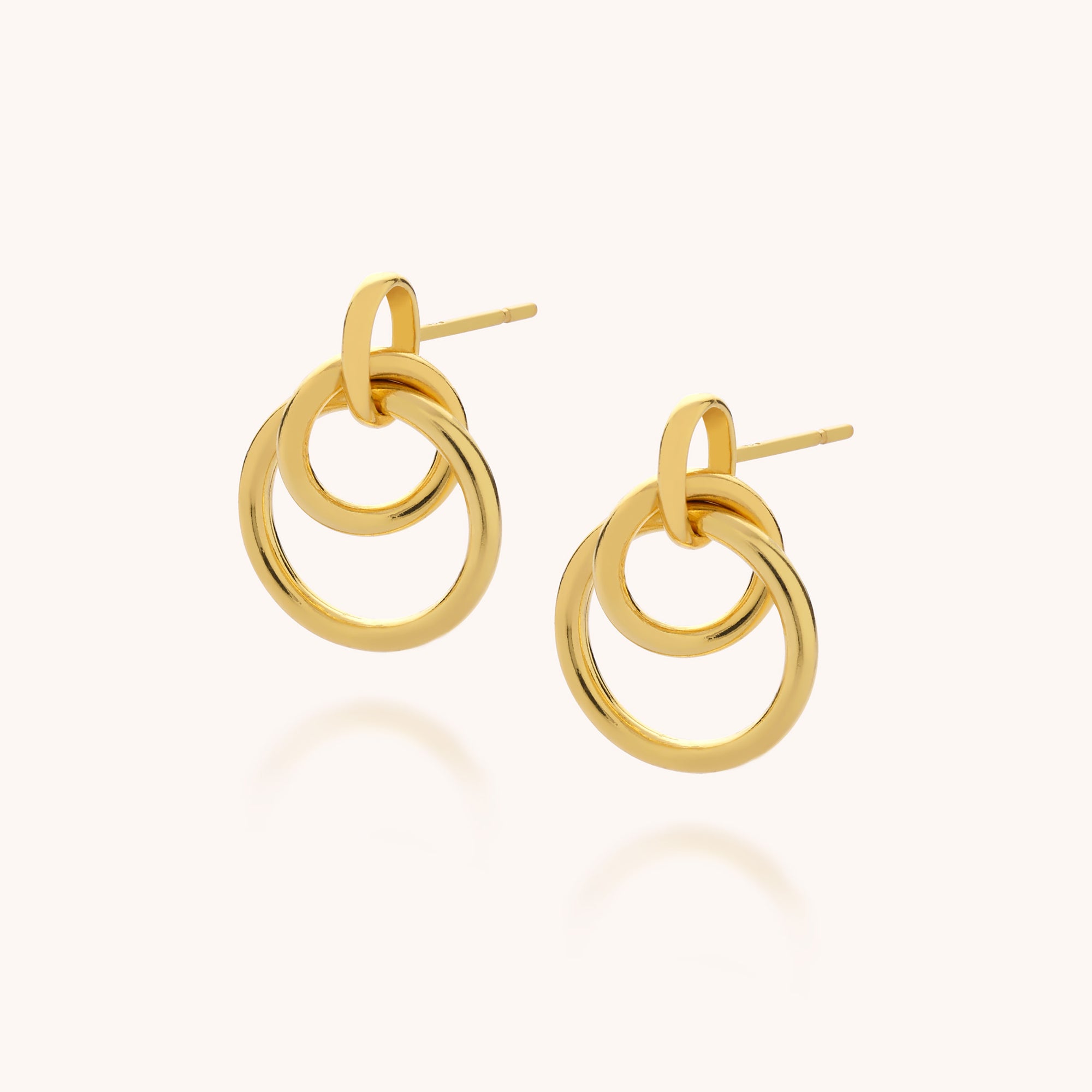 The Double Hoop Ear Drop features two interlocking 18ct gold-plated hoops on each earring, shown against a plain light background.