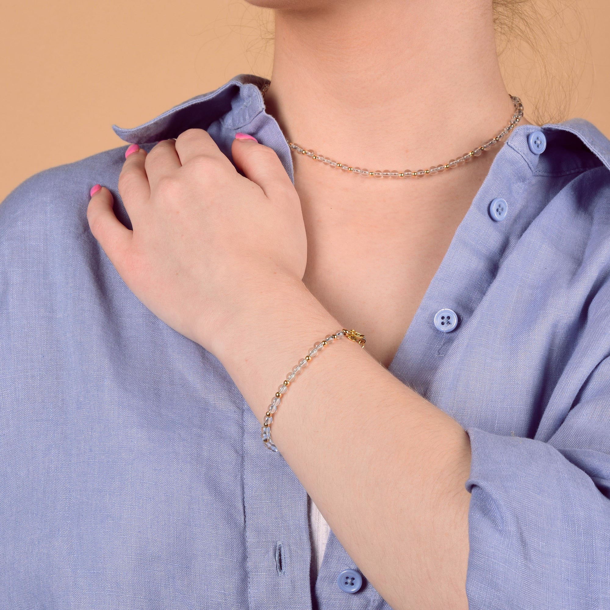 Girl in blue shirt wearing gemstone necklace and bracelet
