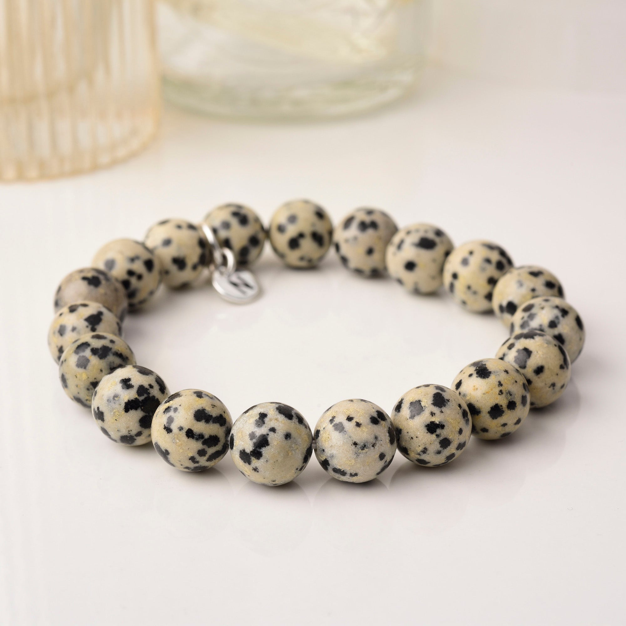 Dalmation jasper gemstone bead bracelet next to vases