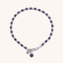 The Linear Birthstone Bracelet features alternating small purple birthstone beads and silver spacers, a silver clasp, and two dangling charms—one natural gemstone and one engraved with a Z.