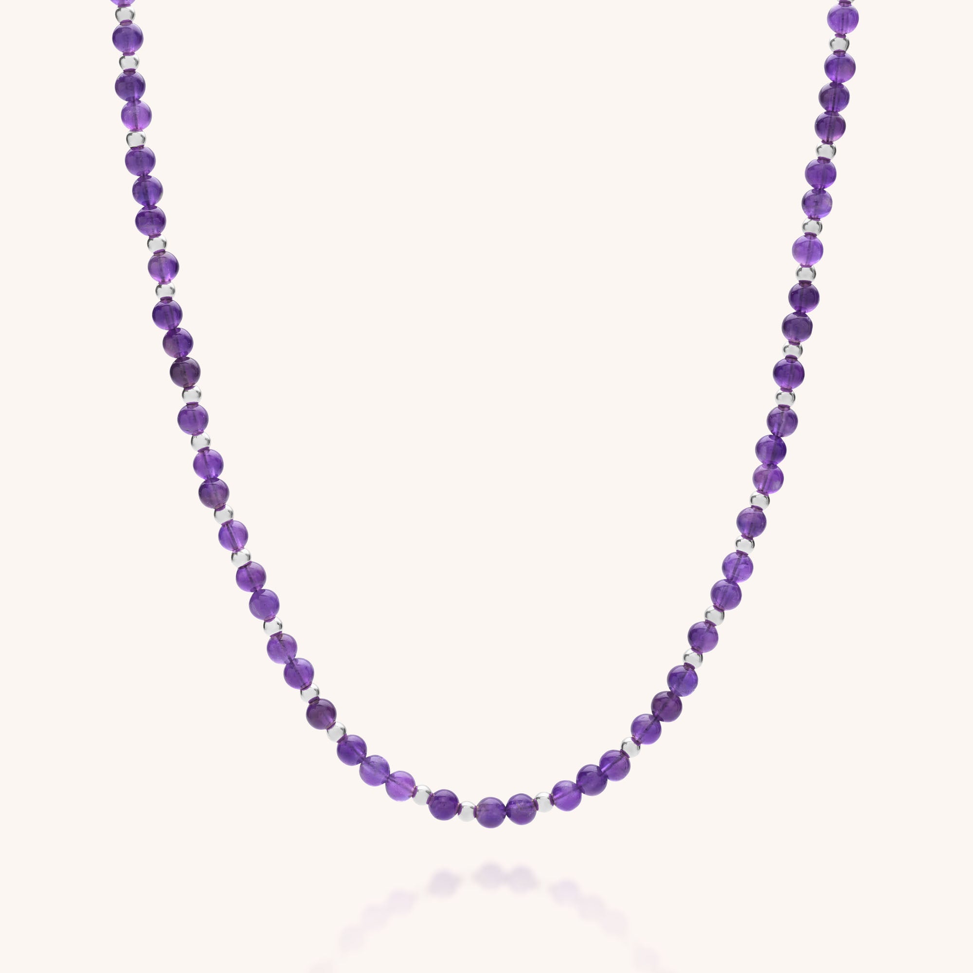 The Jewel Bead Birthstone Necklace - February features small, round, faceted Amethyst beads in a single strand, elegantly displayed against a plain white background.