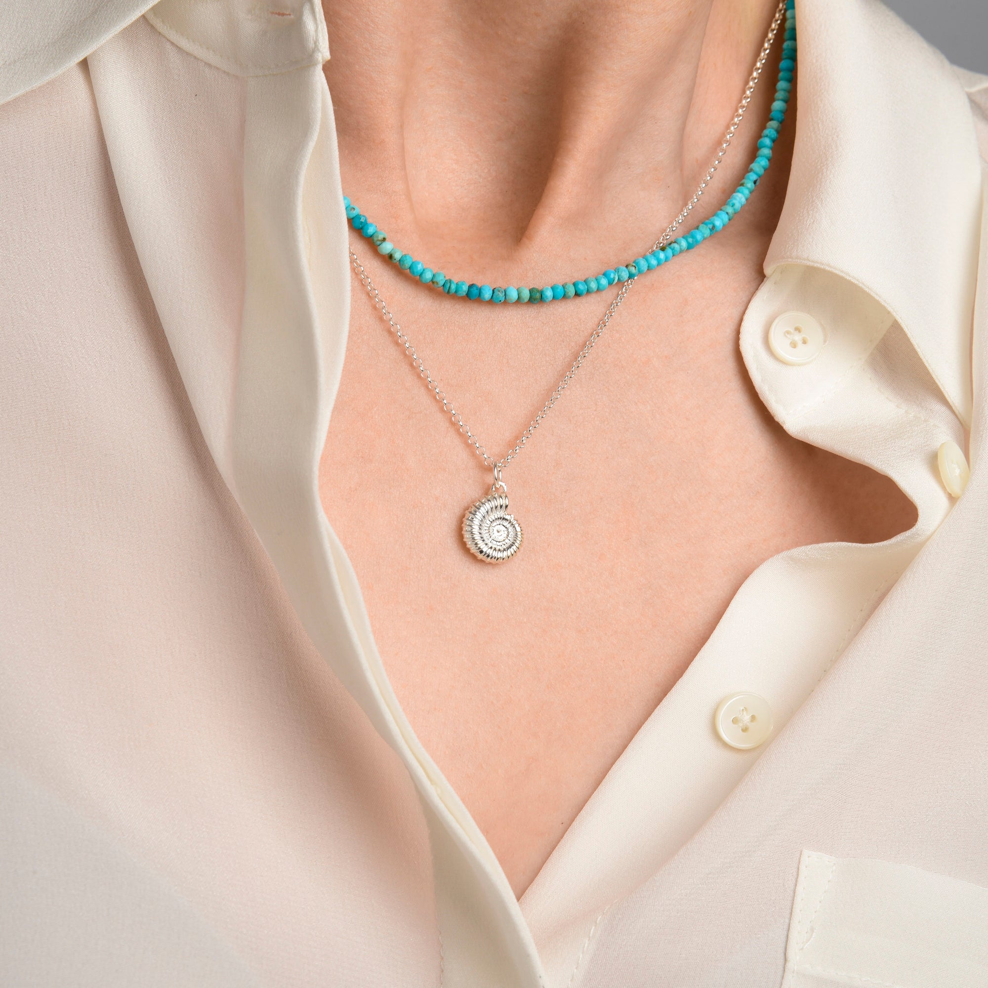 Nellou turquoise gemstone mini bead necklace layered with a sterling silver ammonite necklace jewellery present