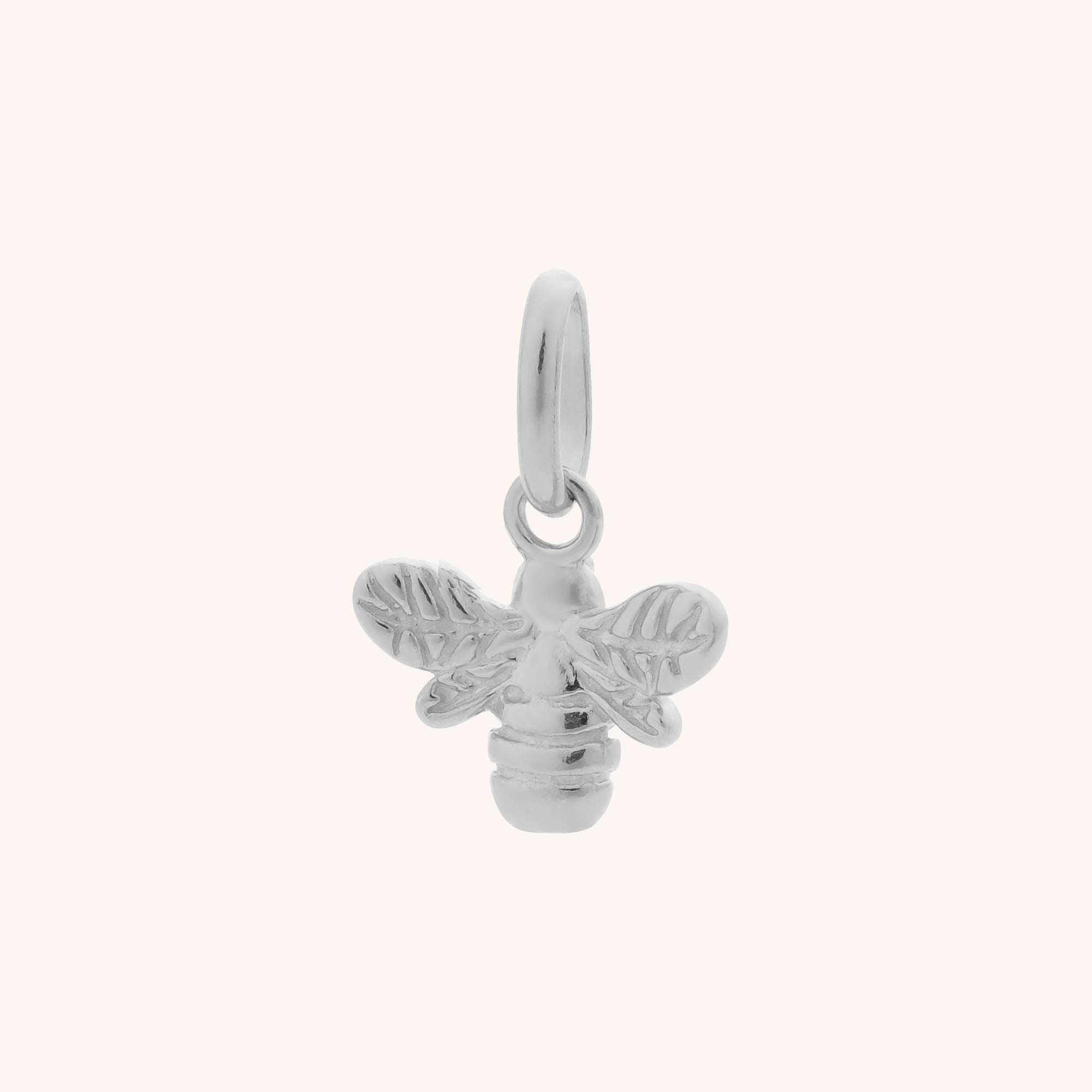 The Bee Charm is a small sterling silver accessory featuring detailed wings and a top loop for attaching to jewelry, shown on a plain light background.