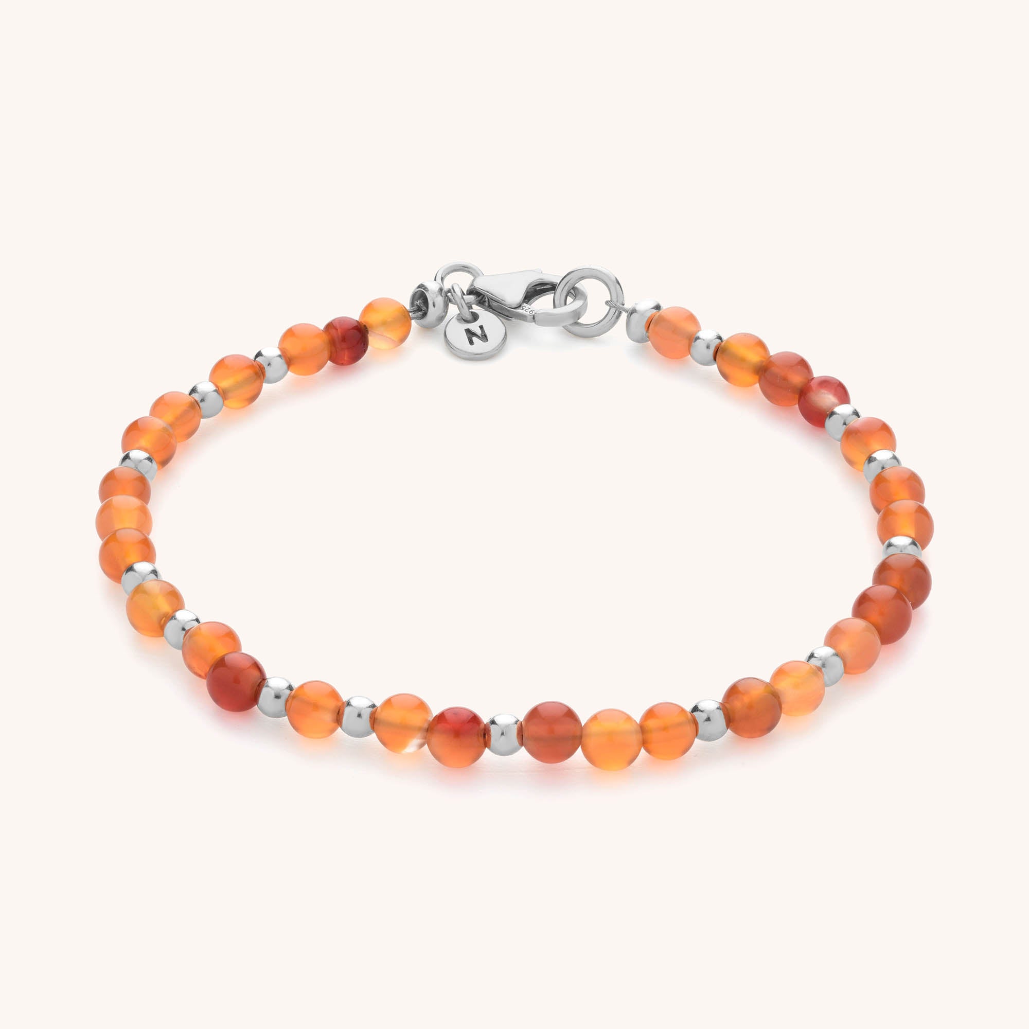 The Jewel Bead Birthstone Bracelet - July features alternating round orange carnelian stones and red beads with eco-friendly sterling silver beads and a silver lobster clasp, displayed on a light background.