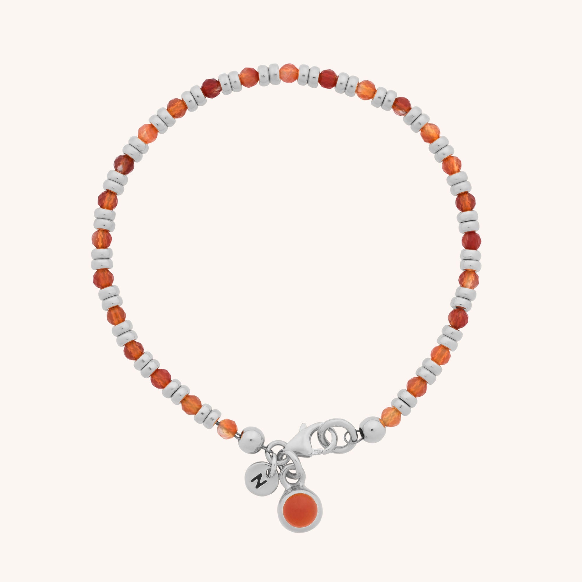 The Linear Birthstone Bracelet - July features alternating orange and silver beads, a silver clasp, and two small charms: one with an orange stone and another engraved with a heart.