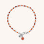 The Linear Birthstone Bracelet - July features alternating orange and silver beads, a silver clasp, and two small charms: one with an orange stone and another engraved with a heart.
