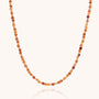 The Jewel Bead Birthstone Necklace - July features alternating small round Carnelian beads in orange, amber, and gold for a simple, elegant look. Carnelian is the birthstone for July.