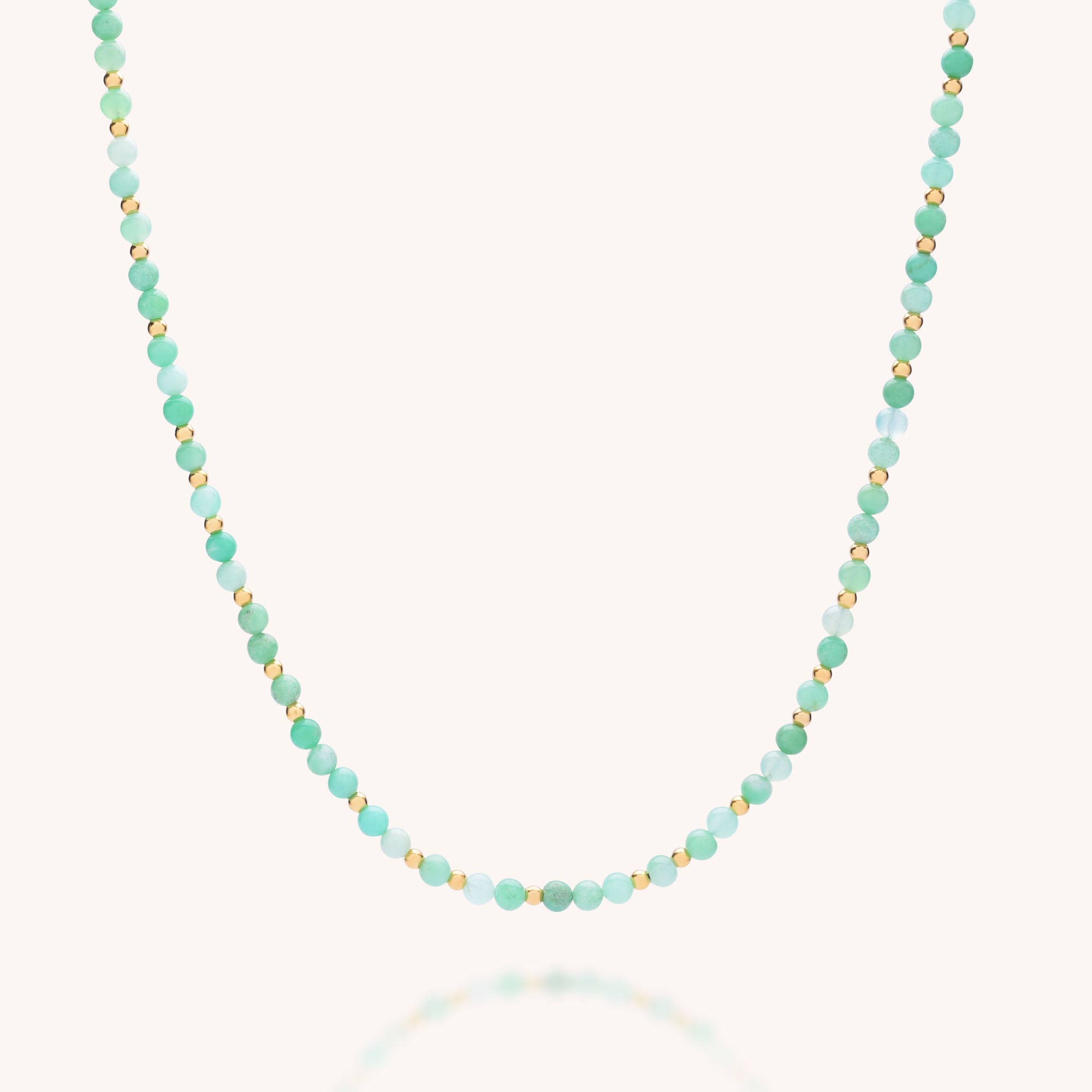 The Jewel Bead Birthstone Necklace - May features delicate chrysoprase with alternating turquoise and gold beads, creating an effortlessly chic, eco-friendly accessory in a simple, elegant design against a light background.