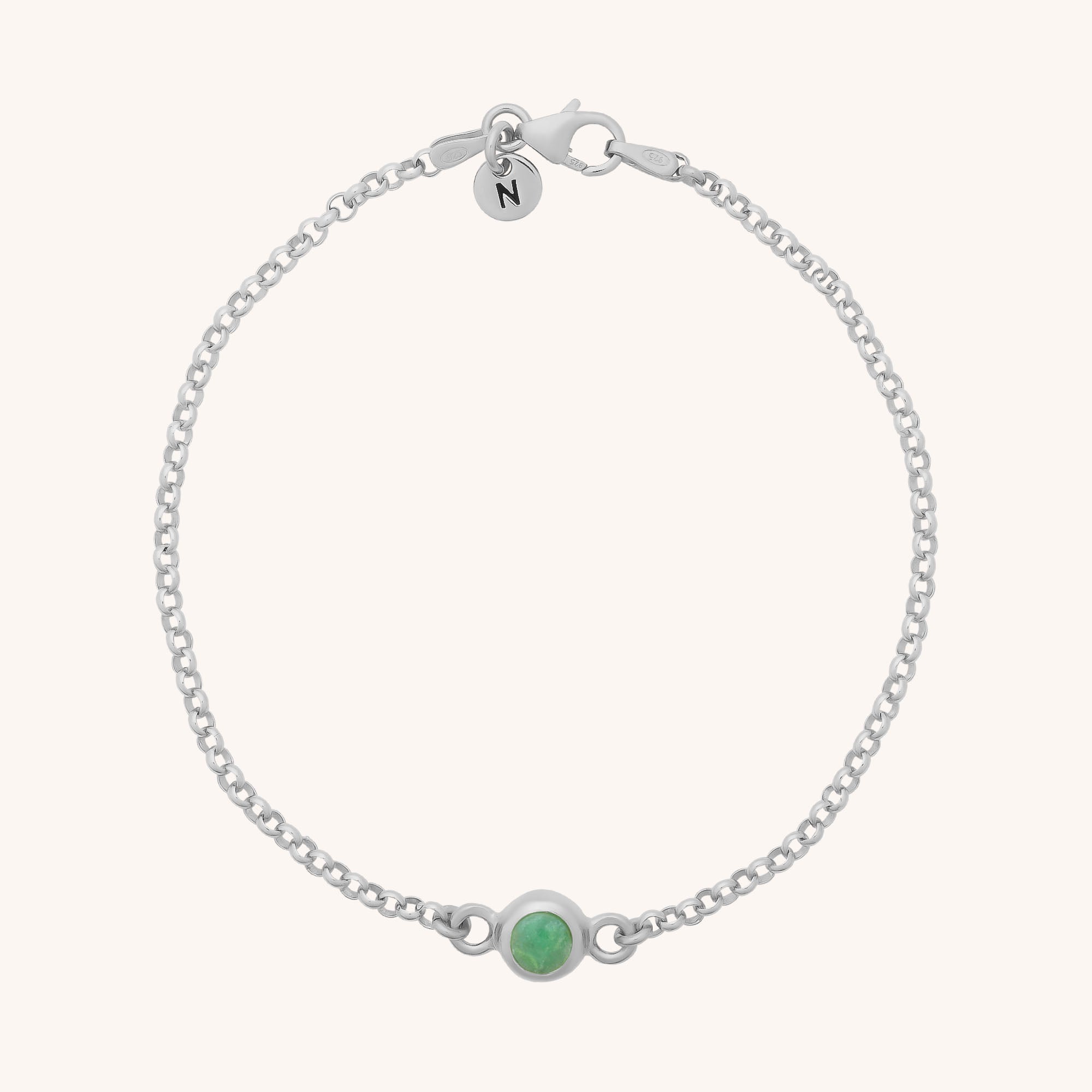 The Birthstone Gem Dot Bracelet - May features a delicate silver chain with a small round natural chrysoprase gemstone at the center and a circular charm engraved with the letter N near the clasp.