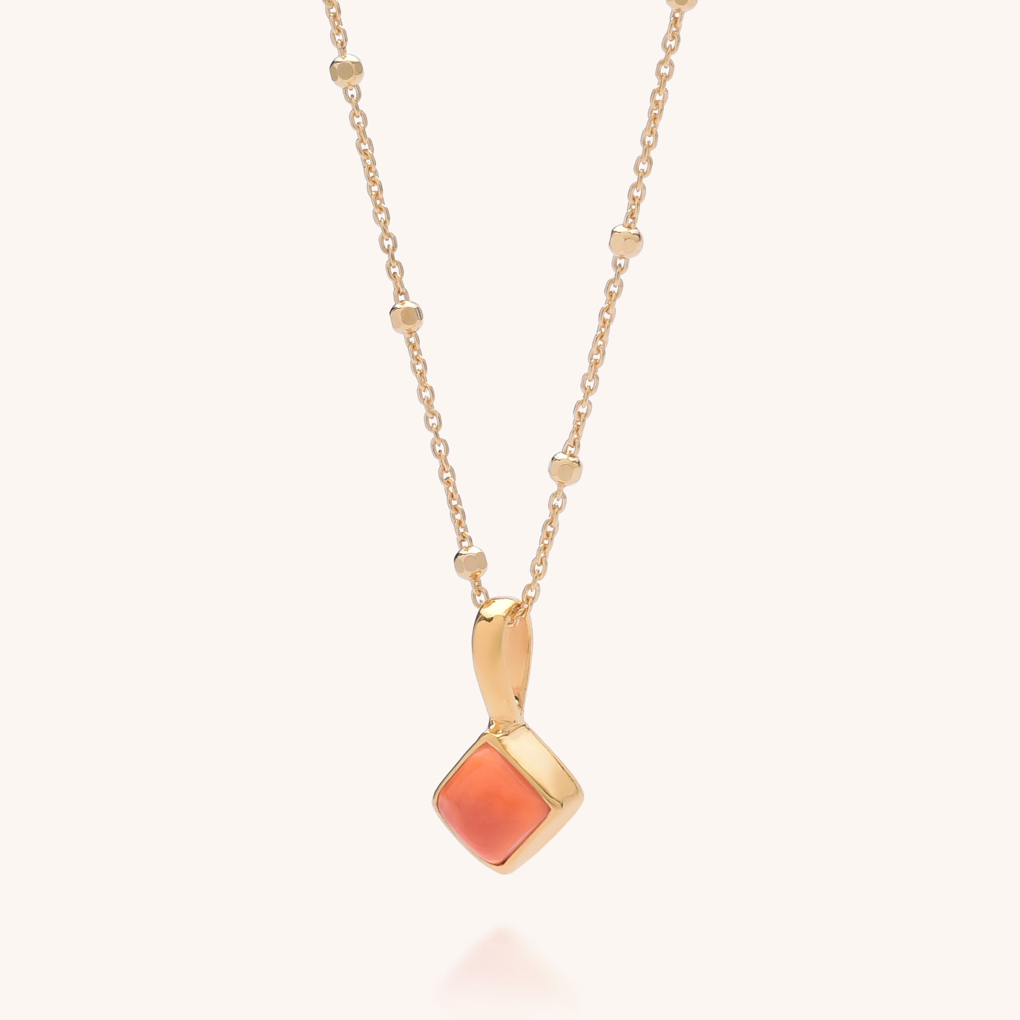 The Diamond Birthstone Necklace July features small gold beads and a square Carnelian gemstone pendant in a gold frame, creating elegant, unique birthstone jewelry. Displayed on a plain light background, it’s perfect for a special touch.