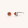 The Mini Gem Dot Birthstone Earrings for July are silver stud earrings featuring round carnelian stones, perfect for a unique touch, displayed on a light background.