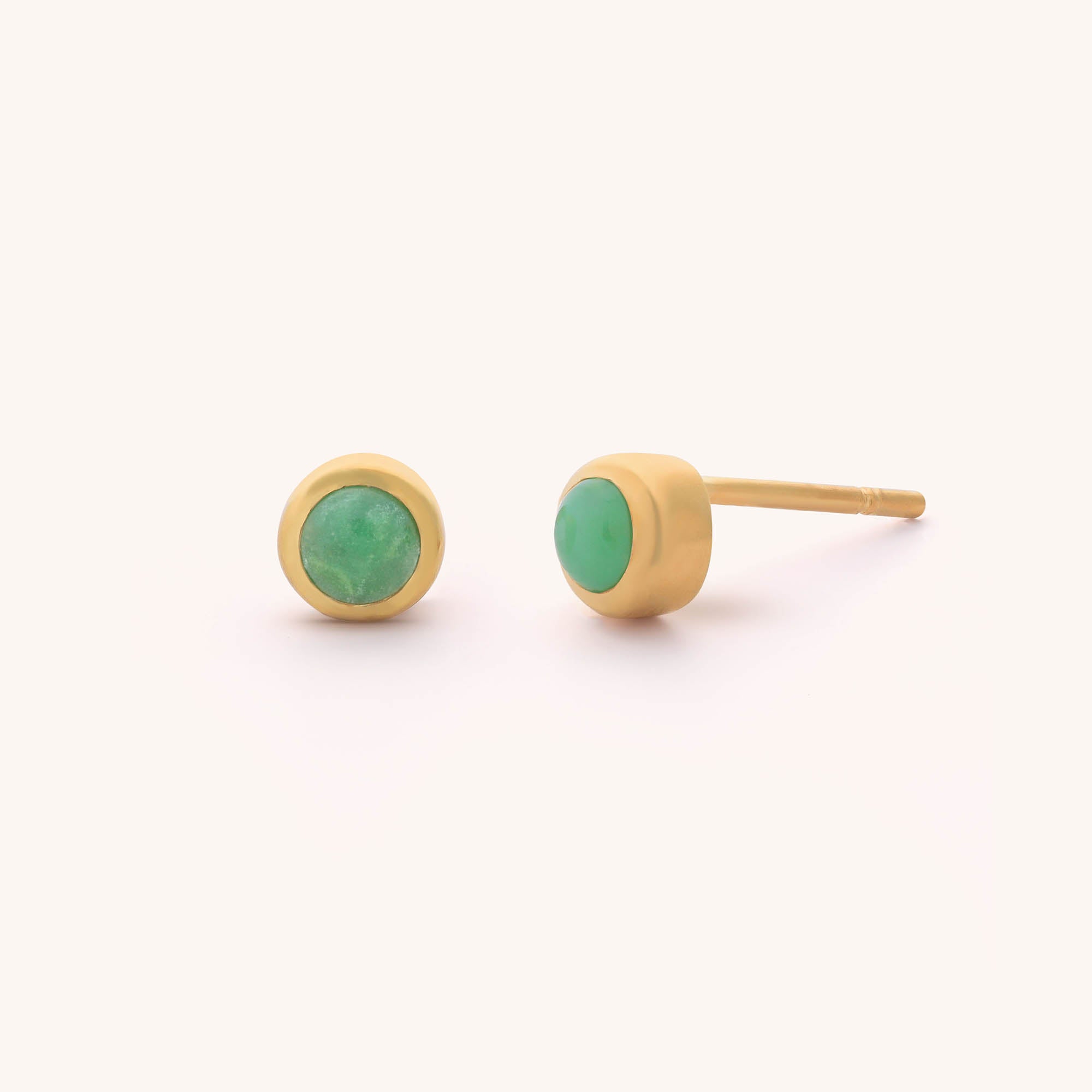 Displayed against a plain white background, the Mini Gem Dot Birthstone Earrings - May showcase two gold studs with round chrysoprase gemstones, highlighting their allure.