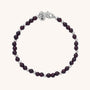 The Jewel Bead Birthstone Bracelet - January features alternating small Garnet and sterling silver beads, a silver clasp, and a round charm engraved with N, shown on a plain light background.