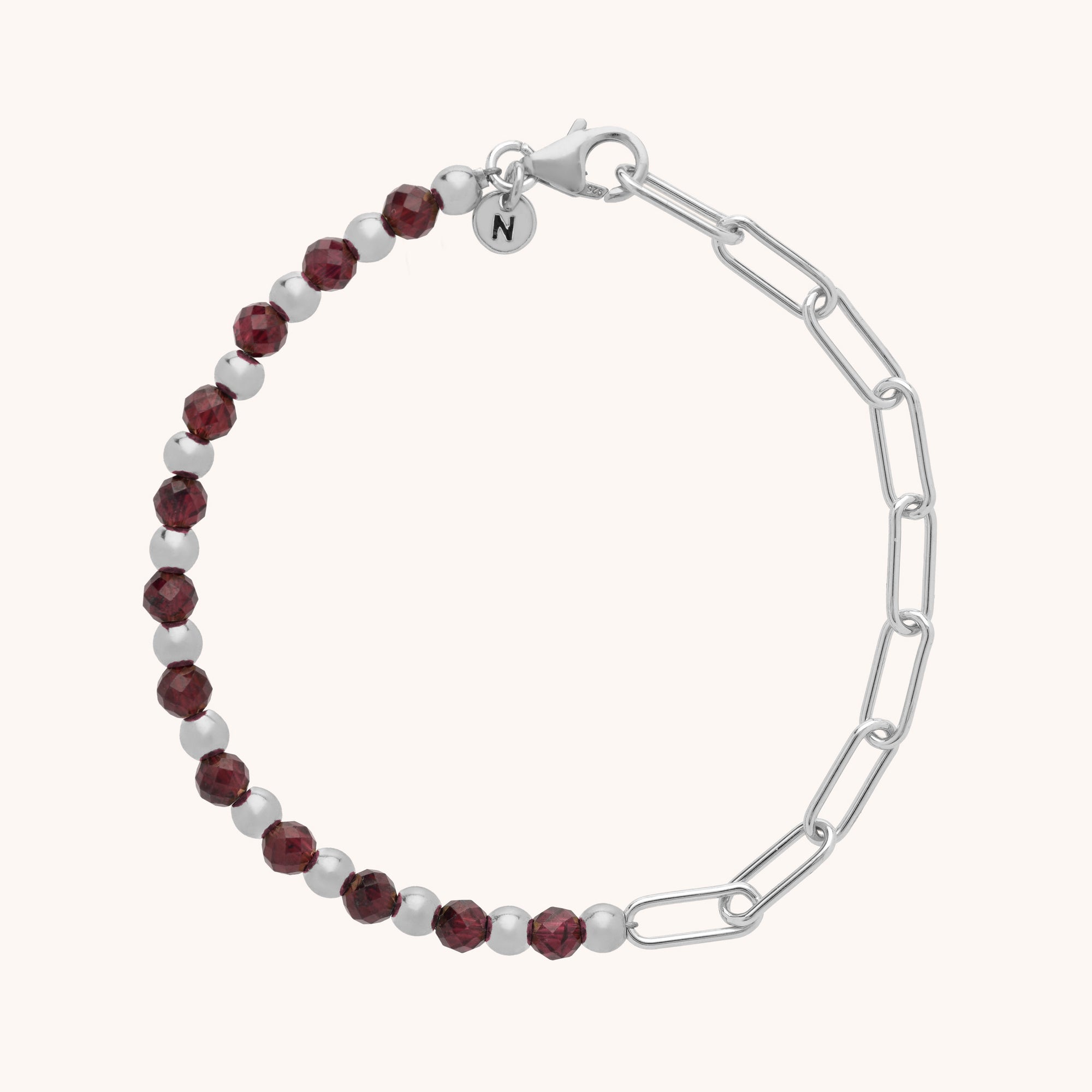 The Gem Shine Bracelet pairs faceted dark red gemstones and eco-silver sterling silver on one half with sleek chain links and a delicate round charm on the other.
