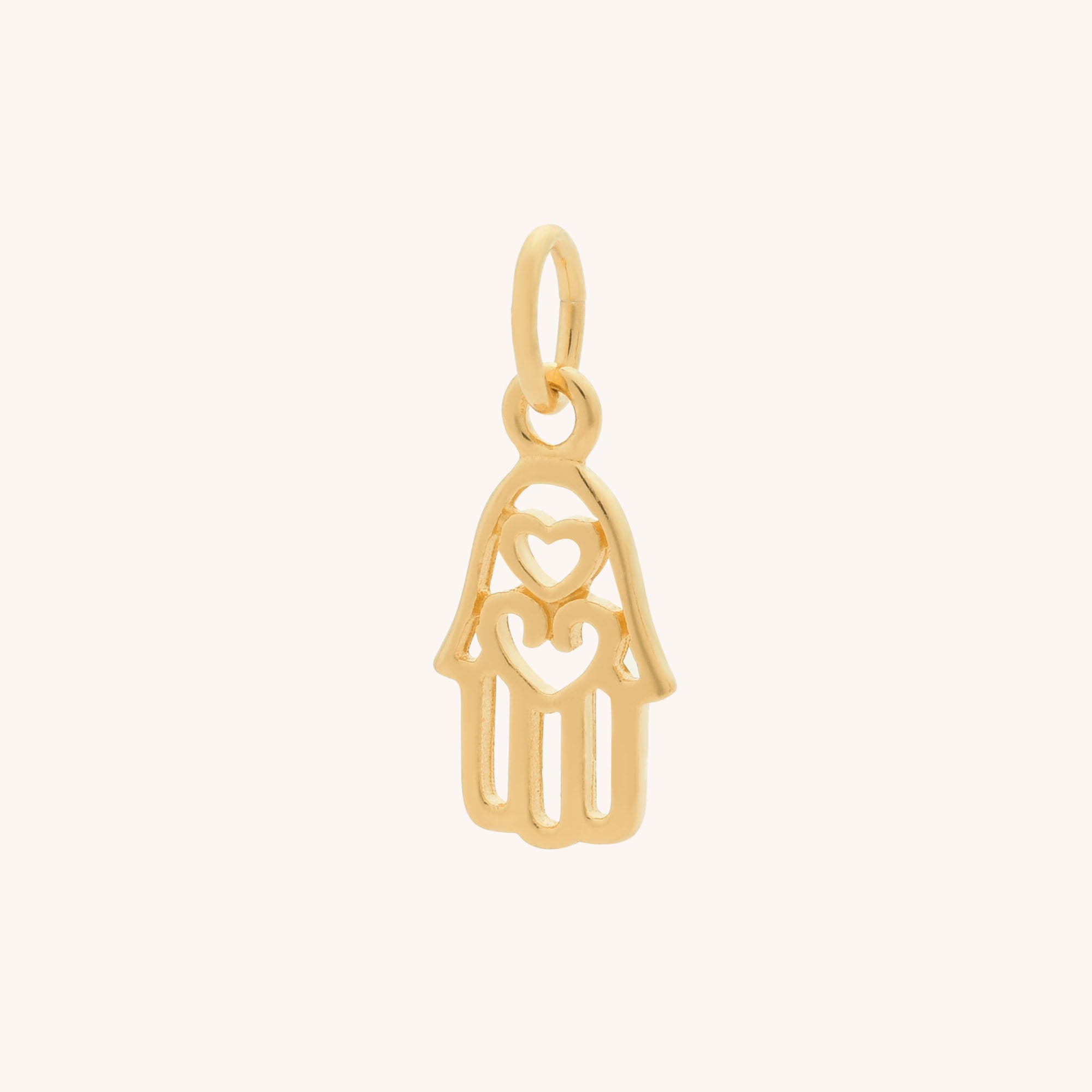 The Hamsa Hand Charm features a gold openwork design with two central hearts and a small loop for hanging—a beautiful symbol of spirituality and protection.