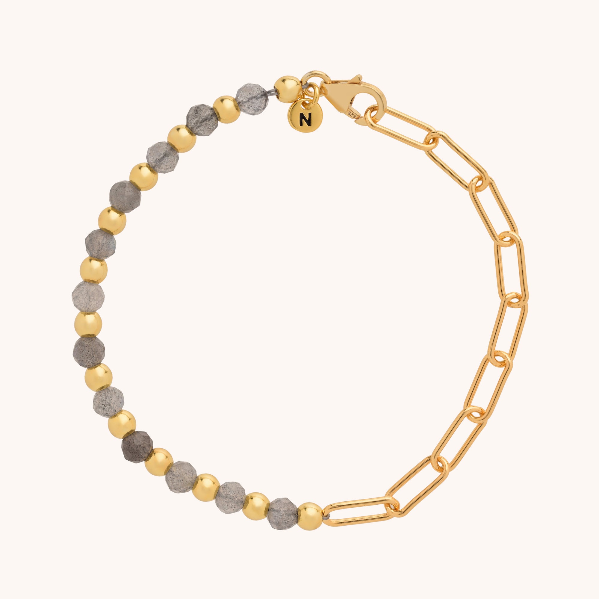 The Gem Shine Bracelet pairs half gold and half grey natural gemstone beads with a gold paperclip chain, finished with a clasp and a round charm engraved with N.