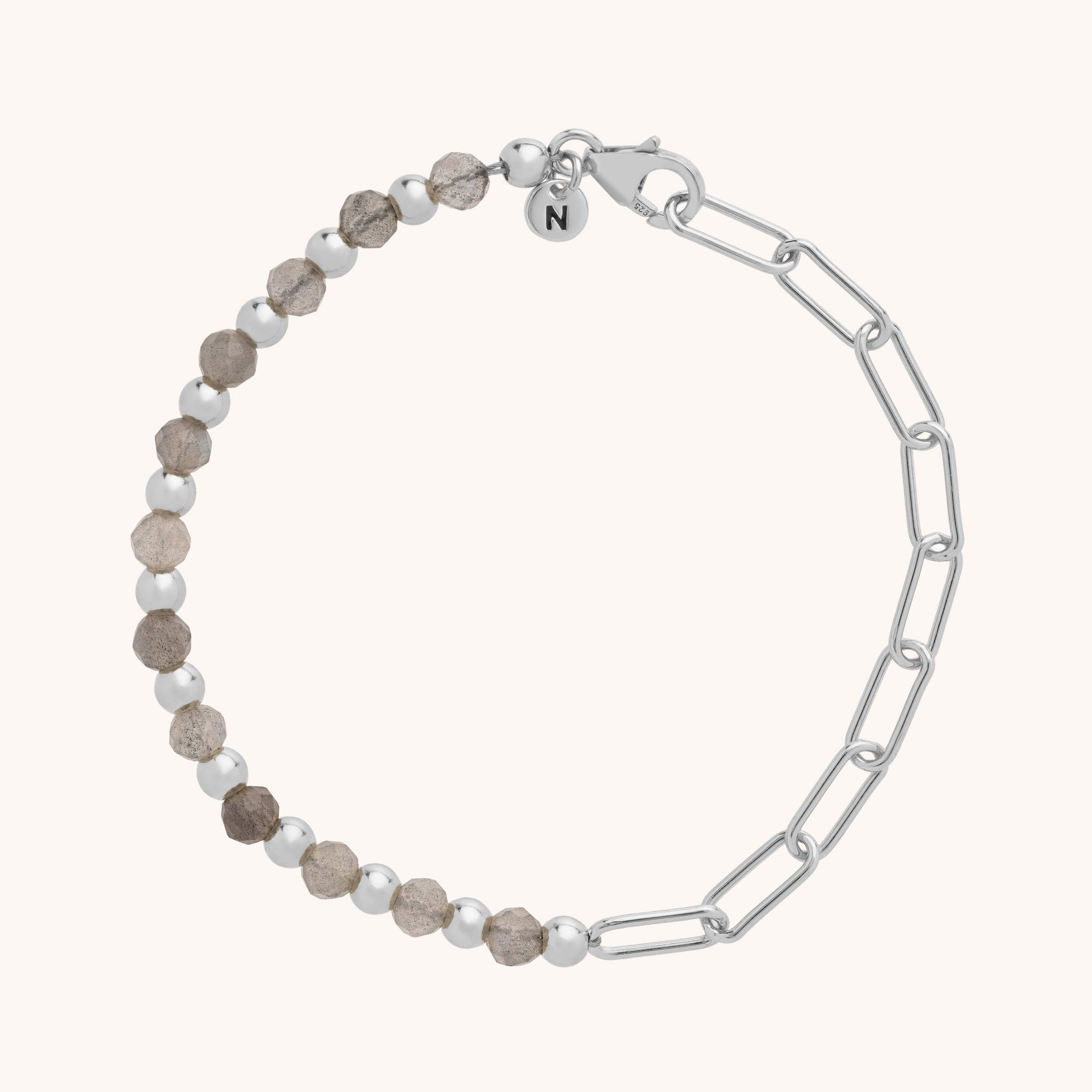 The Gem Shine Bracelet has half eco-silver sterling silver chain links and half alternating silver and textured brown round beads, finished with a clasp and a circular charm engraved with N.