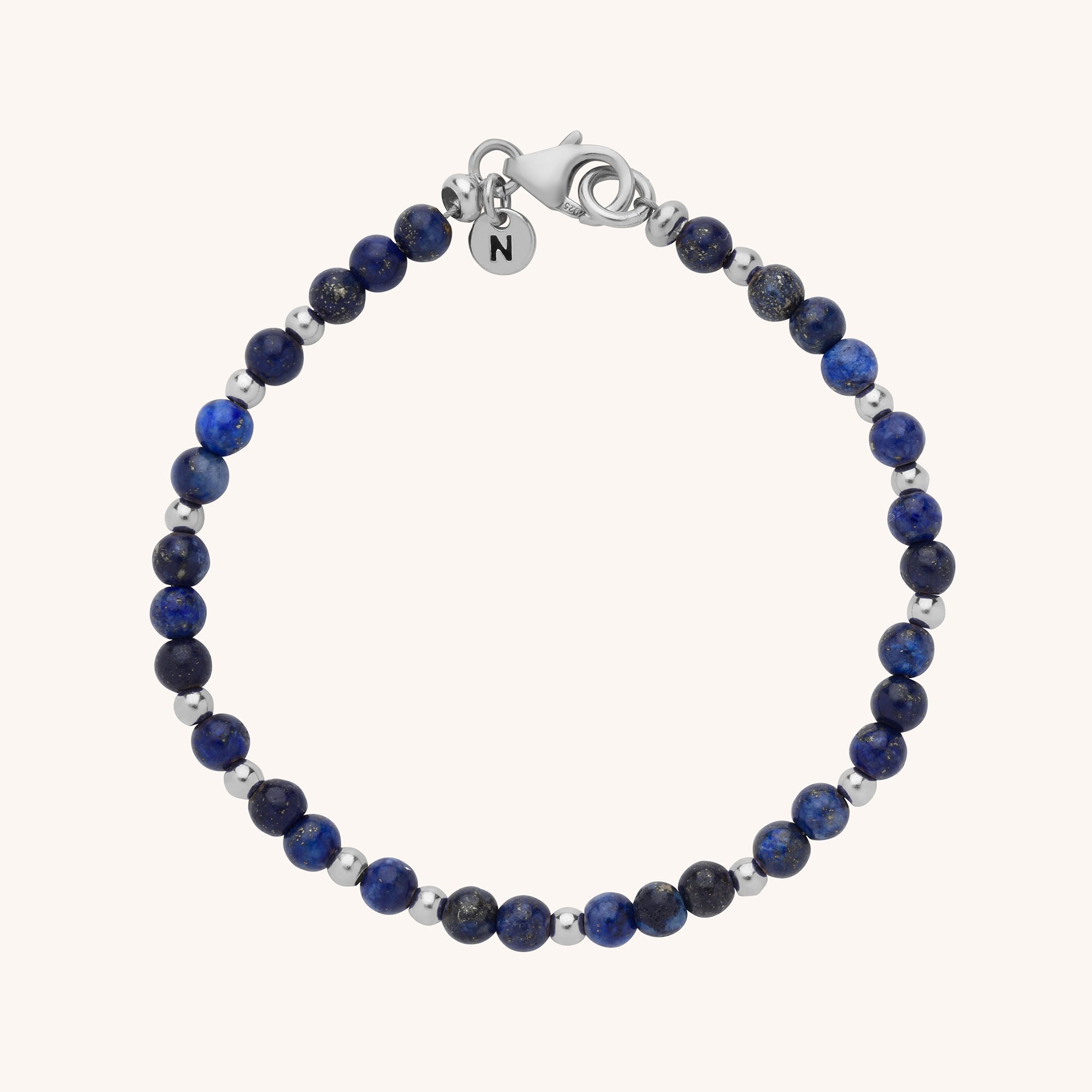 A handmade Jewel Bead Birthstone Bracelet featuring alternating dark blue and metallic silver round beads, finished with a silver lobster clasp and a small engraved round tag with the letter N.