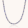 The Jewel Bead Birthstone Necklace - September showcases small round navy blue and gold beads arranged in a simple, elegant design—a beautifully handcrafted piece of UK jewelry.