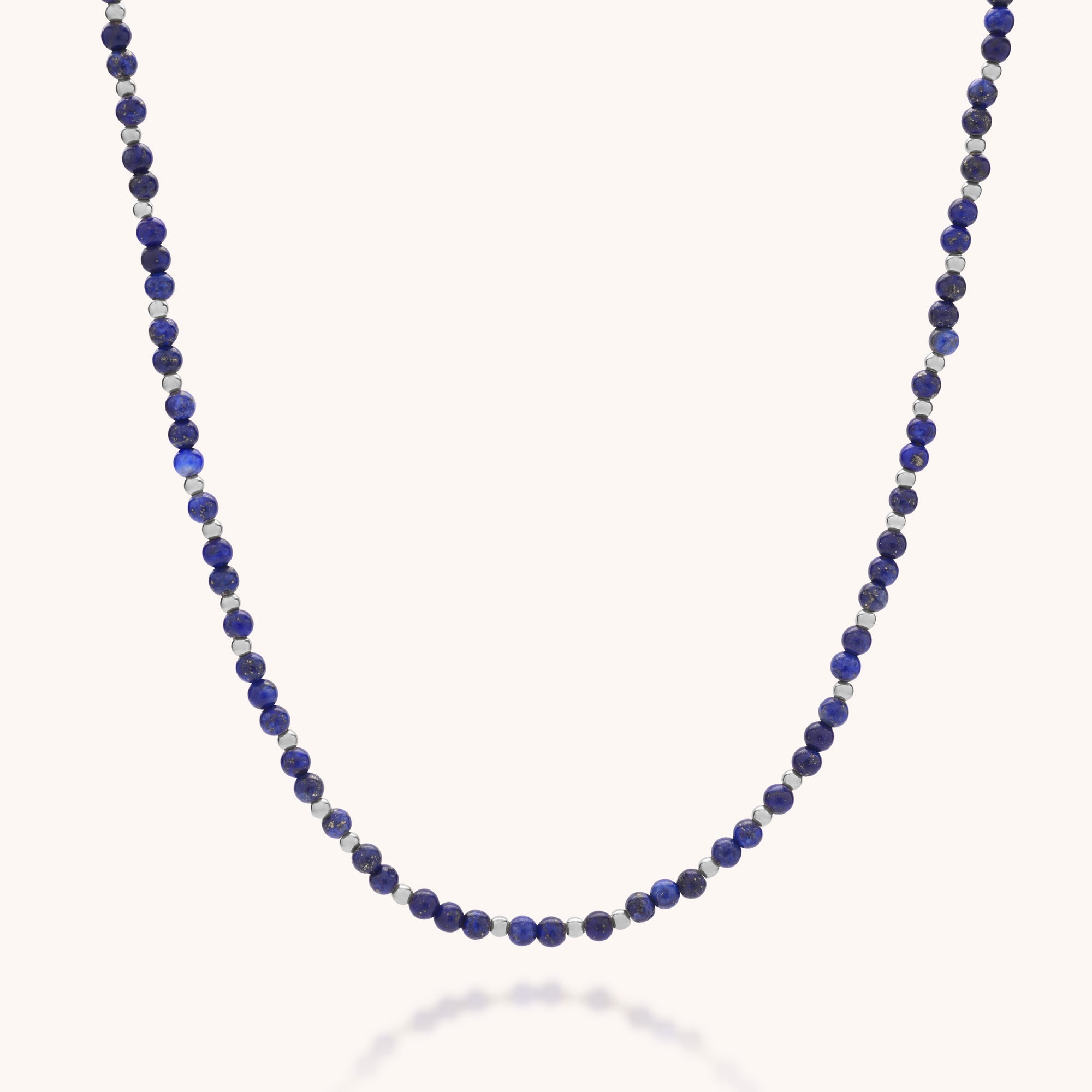 The Jewel Bead Birthstone Necklace - September features small, round lapis lazuli beads strung on a thin chain, showcasing eco-friendly craftsmanship and beautifully presented against a plain white background.