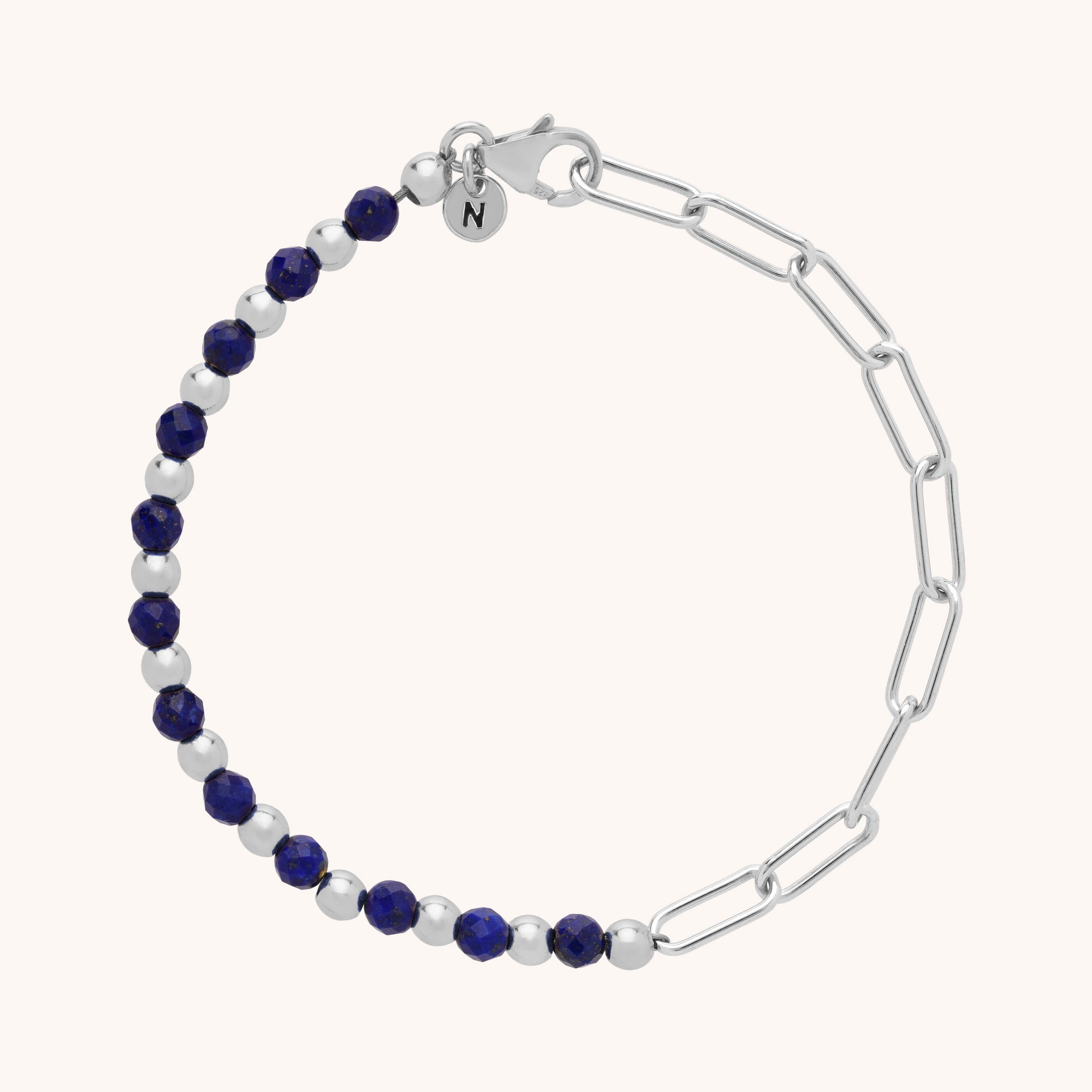 The Gem Shine Bracelet showcases alternating silver and dark blue gemstones on one side, paired with eco-silver elongated chain links and a small round charm by the clasp.