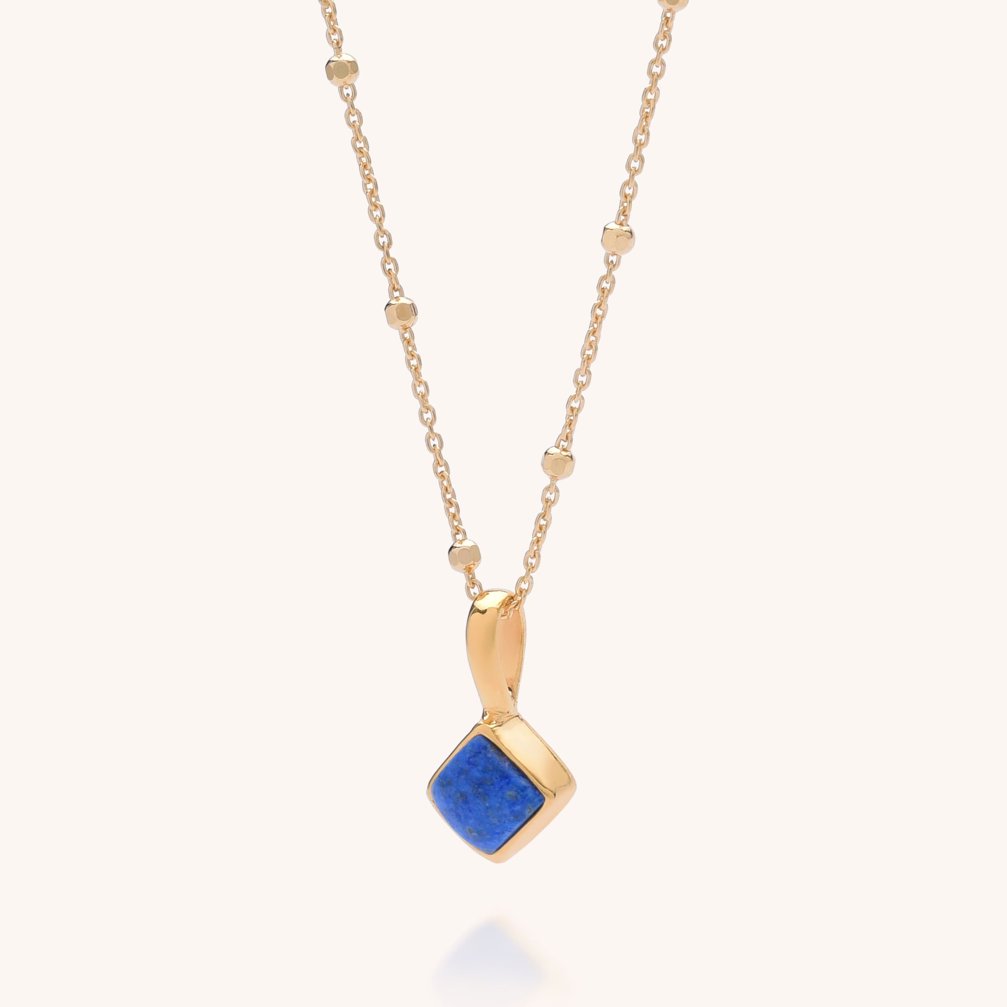 Diamond Birthstone Necklace September featuring a square blue lapis gemstone pendant set in a gold frame with small round beads, displayed against a plain light background.