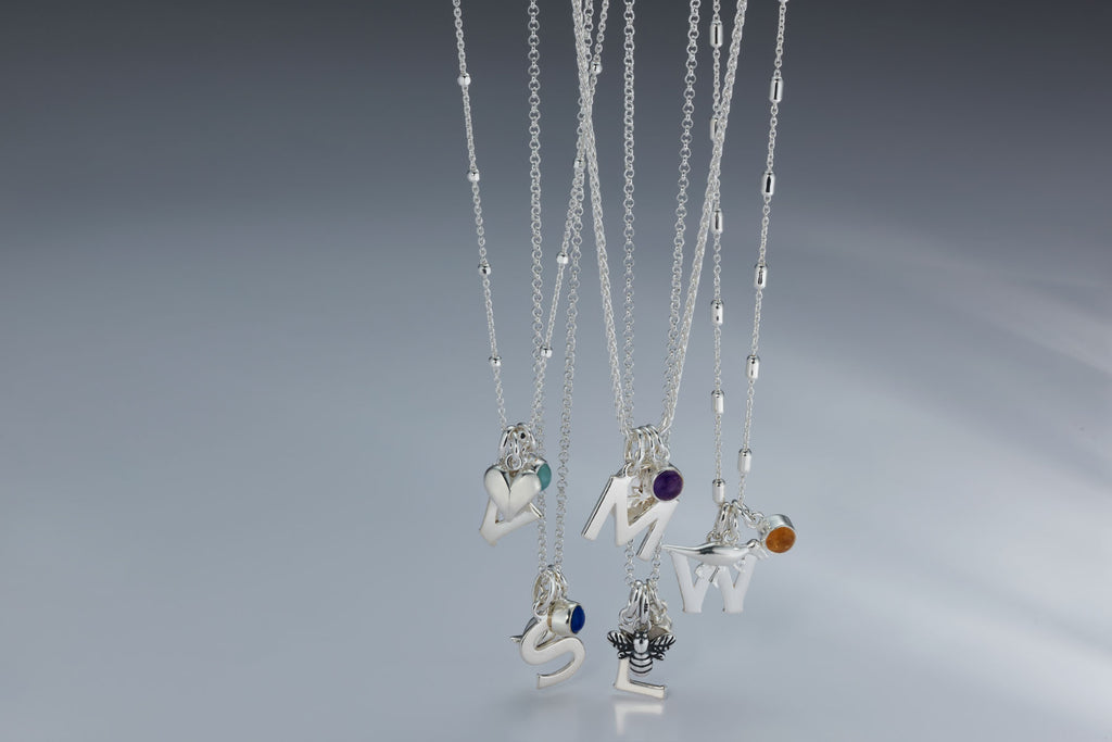 Necklace with letter pendants,  birthstones and charms hanging in a cluster