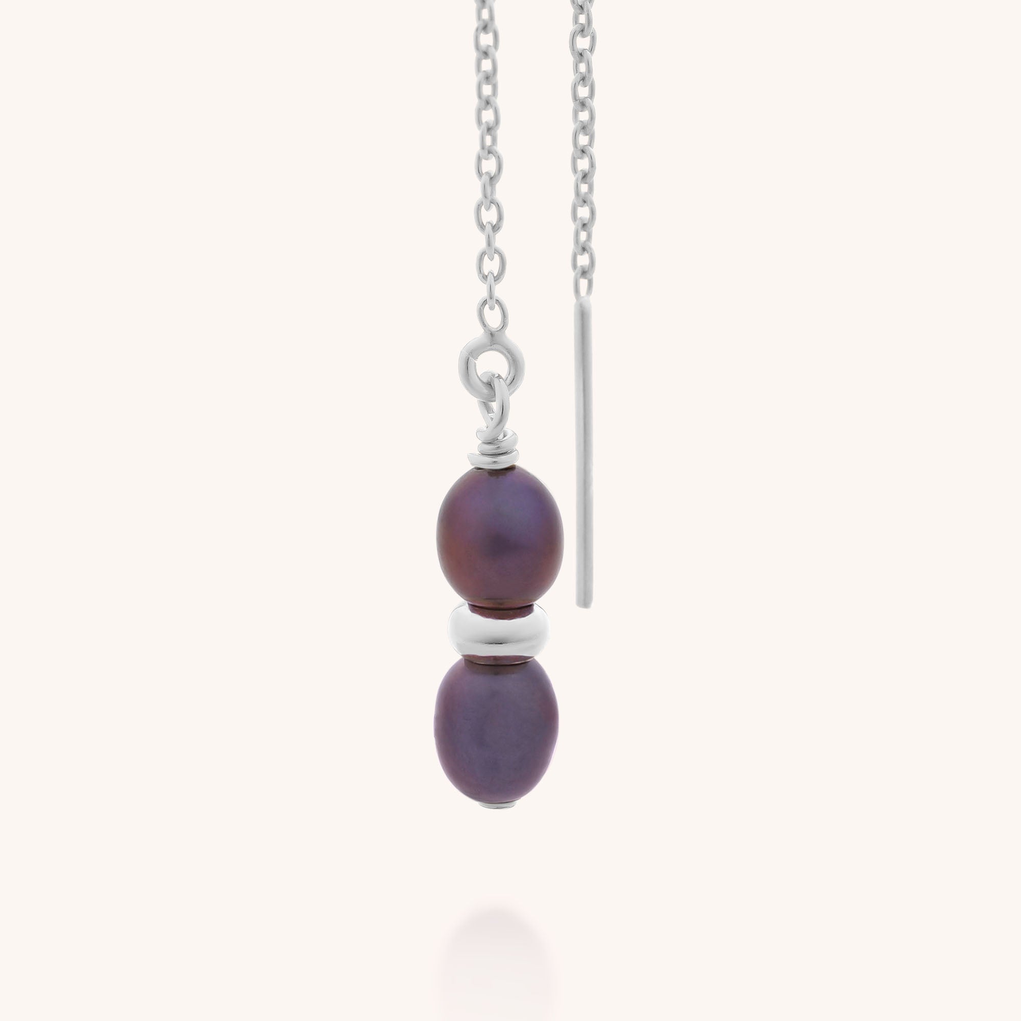The Ellen Pearl Fall Earrings feature two stacked purple beads separated by a silver spacer and finished with a slim vertical silver bar, displayed against a plain light background.
