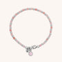 The Linear Birthstone Bracelet features alternating pink, white, and silver beads, a silver lobster clasp, and two charms—one with an N and one with a pink stone—making it perfect for gemstone jewelry lovers.