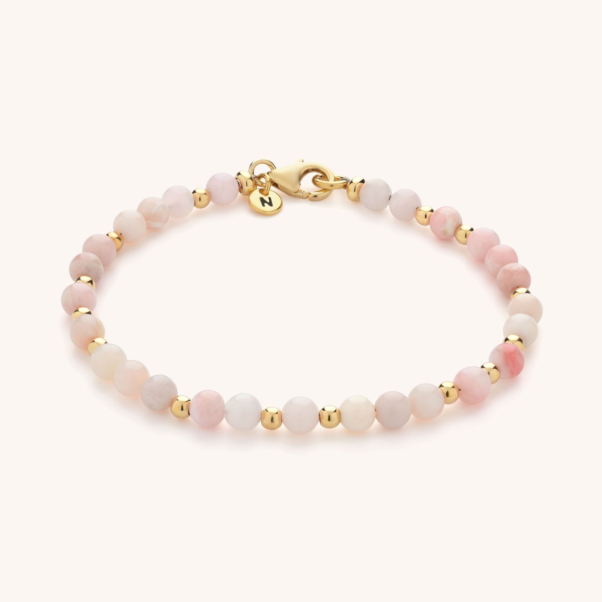 Jewel Bead Birthstone Bracelet with small round pink and gold beads, finished with a gold clasp and round gold charm—a perfect handmade jewellery piece.