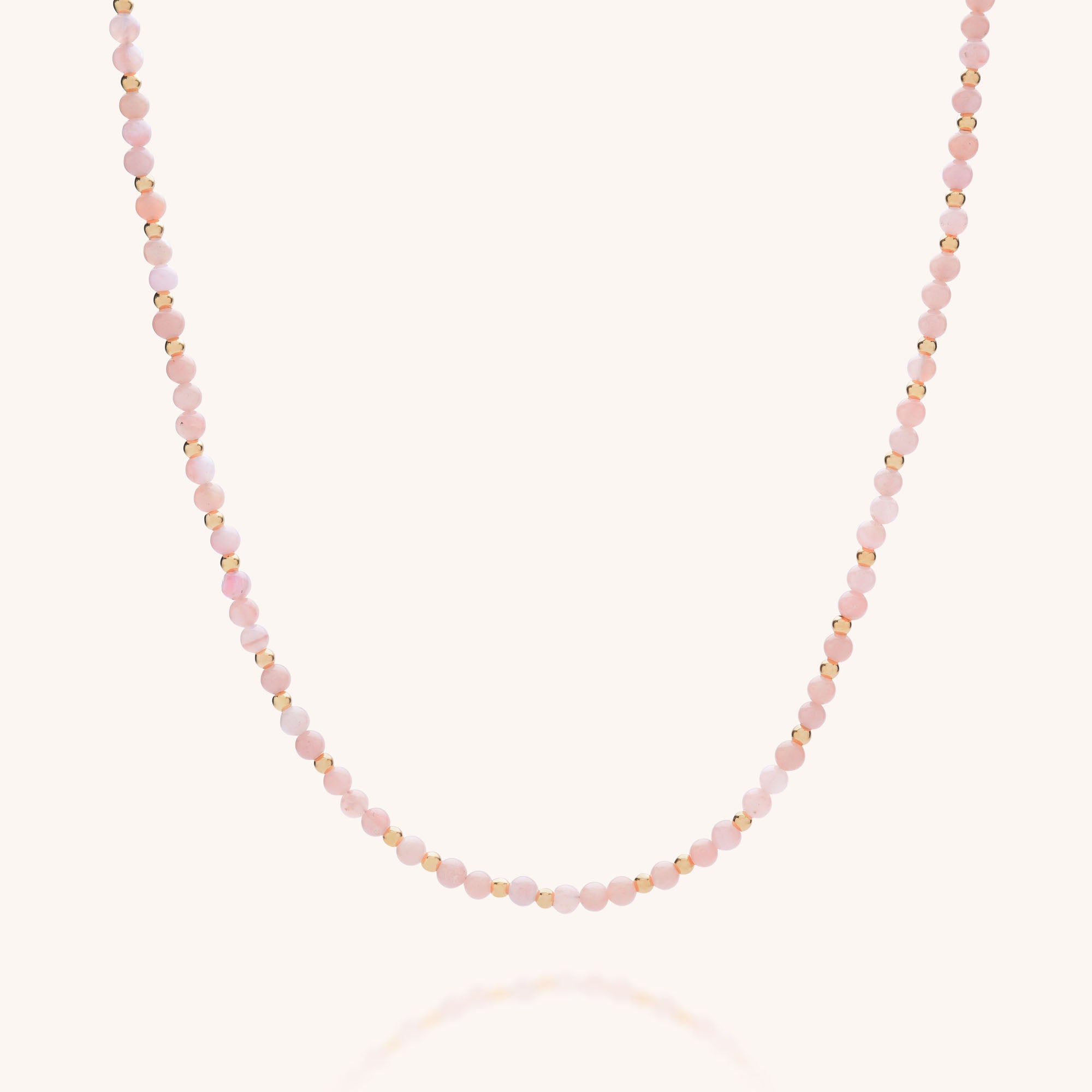 The Jewel Bead Birthstone Necklace - October features alternating small round Pink Opal and gold beads, shown against a plain light background.