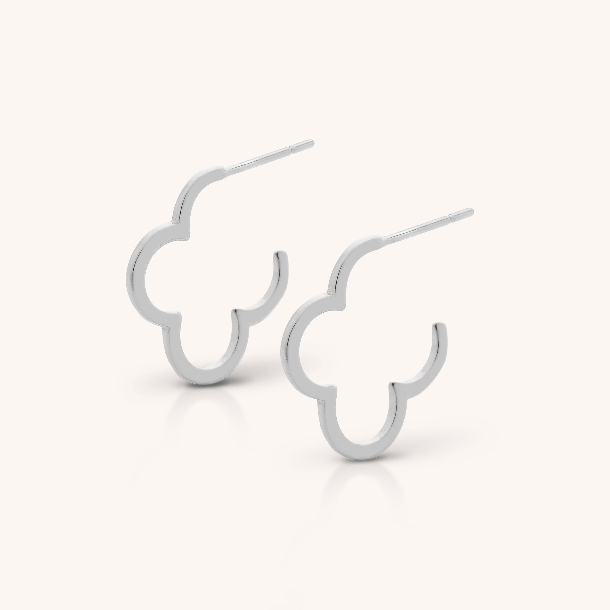 The Clover Hoop Earrings are sterling silver hoops featuring abstract, rounded quatrefoil outlines, shown against a plain light background.