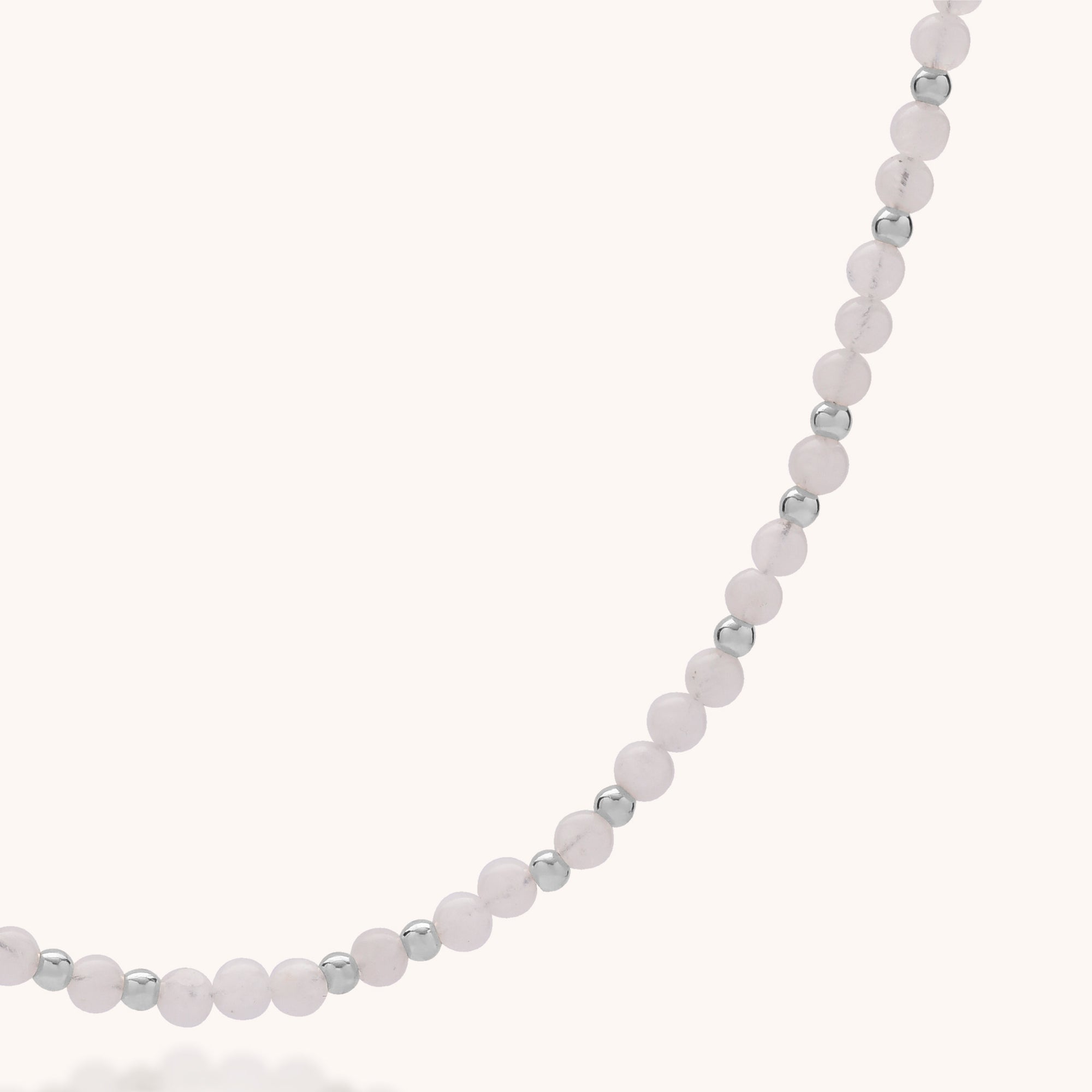 A close-up of the Jewel Bead Birthstone Necklace - June, featuring alternating light pink round beads and small eco-friendly sterling silver beads, displayed on a light background.
