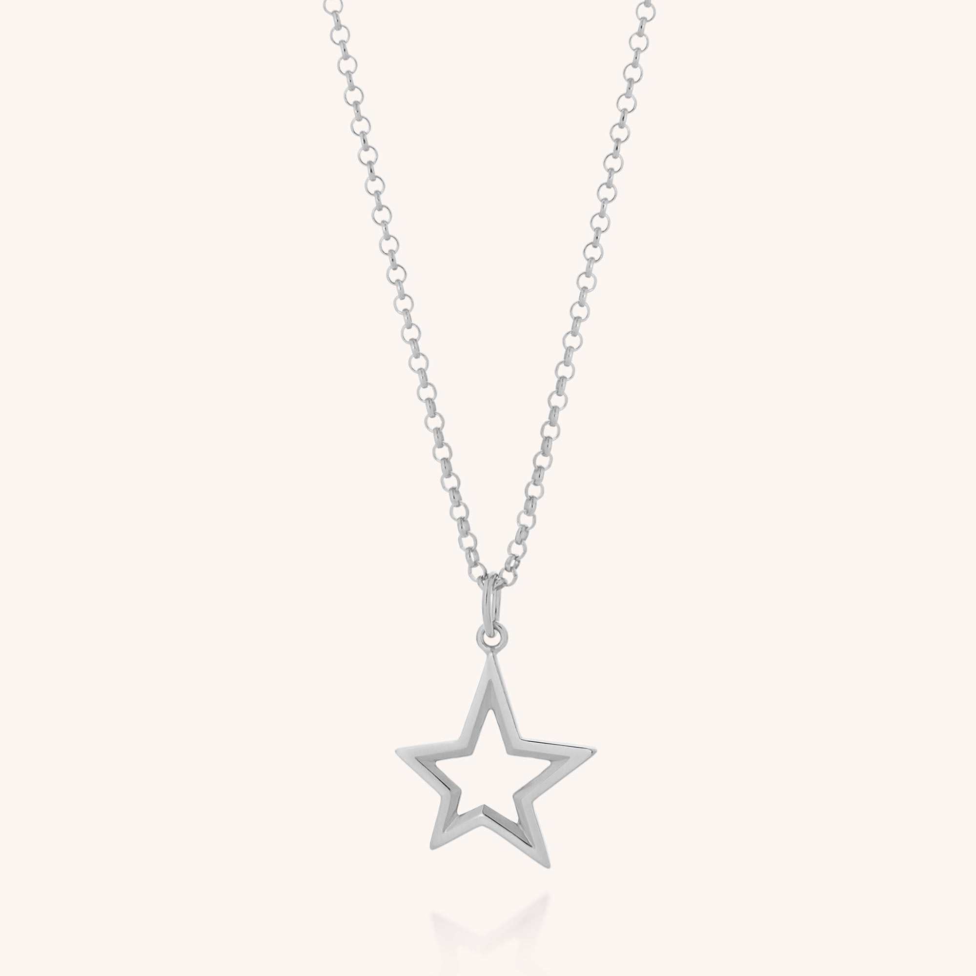 The Northern Star Necklace features a sterling silver chain and an open star-shaped pendant, creating celestial charm against a light background.