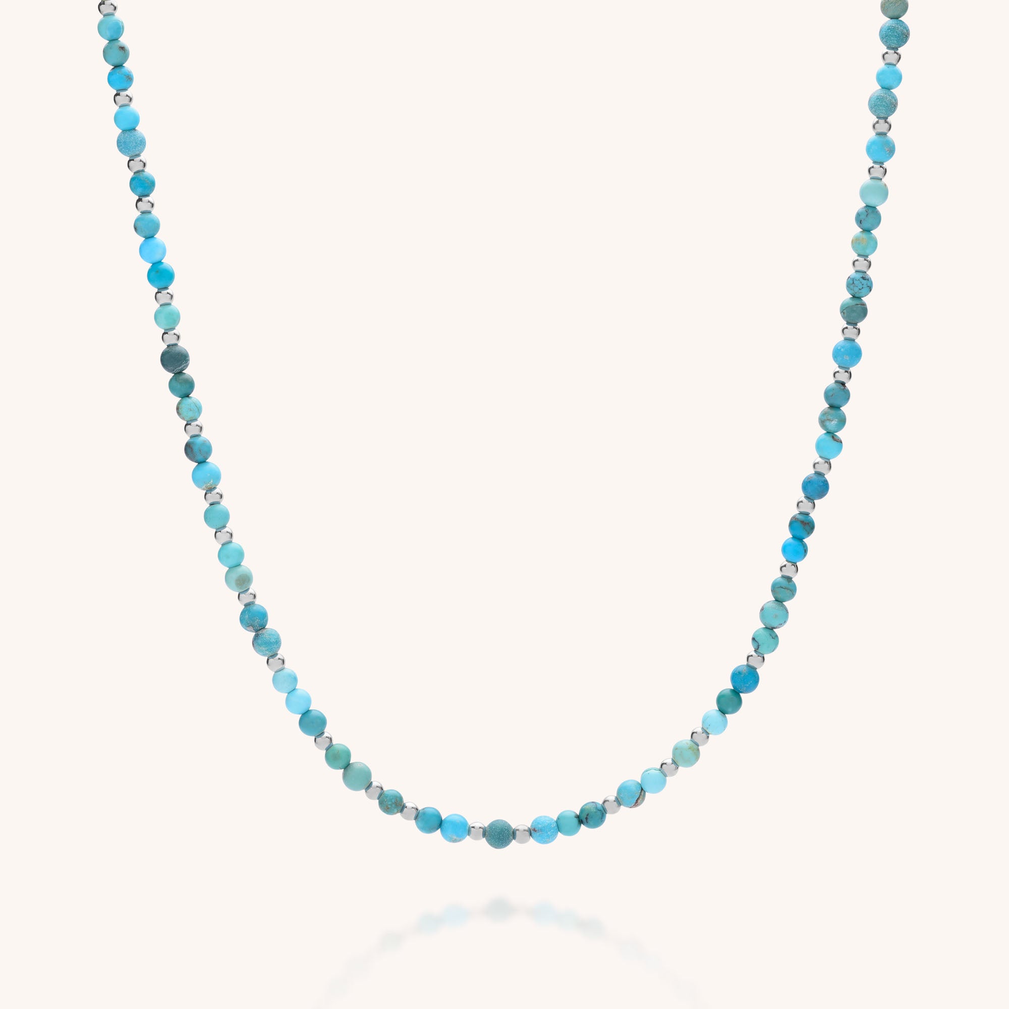 The Jewel Bead Birthstone Necklace - December features small, round turquoise beads in blue and green shades, evenly spaced on an eco-friendly sterling silver strand, shown against a plain white background.