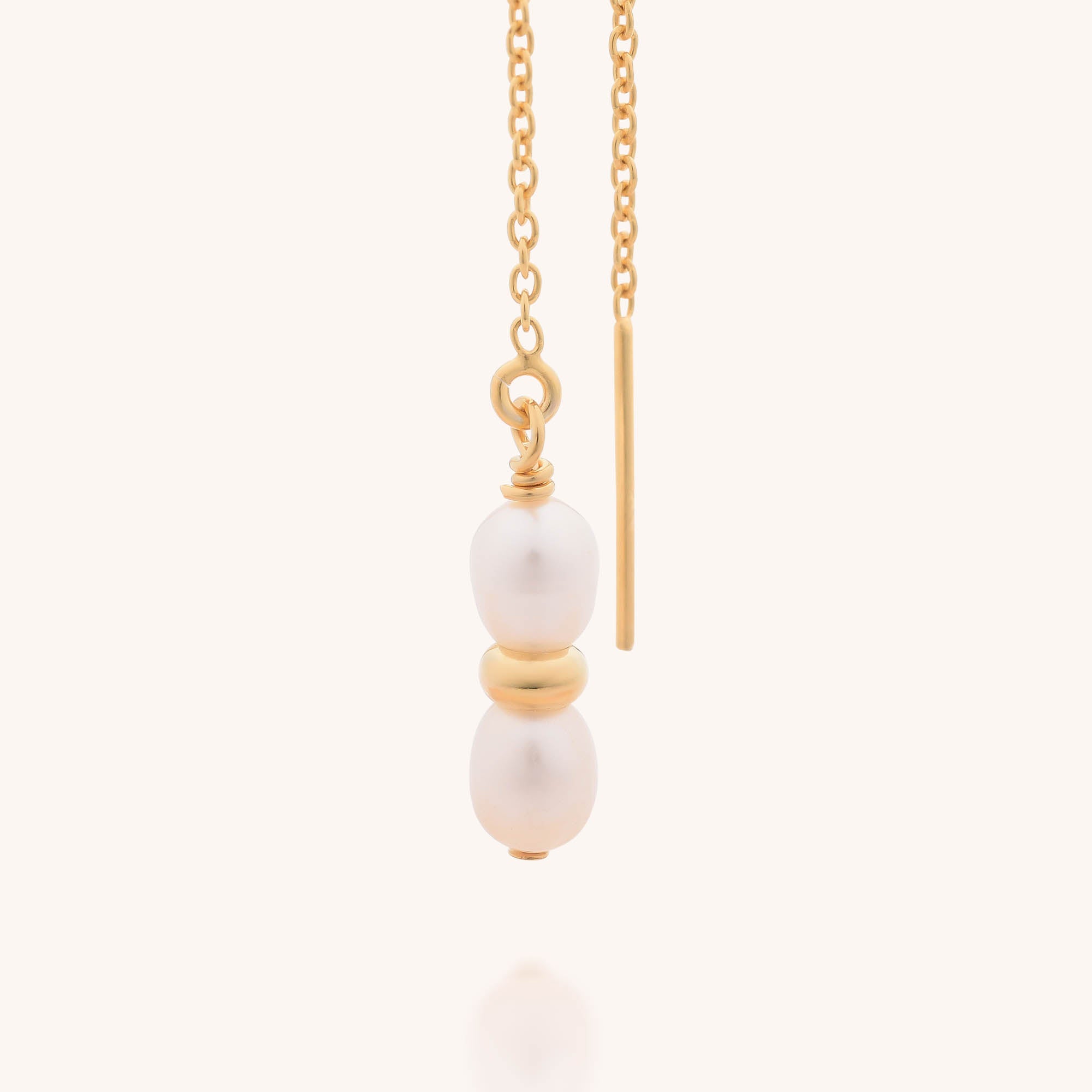 The Ellen Pearl Fall Earrings feature two freshwater pearls stacked with a gold bead between them and a slim vertical gold bar, all crafted in sterling silver.